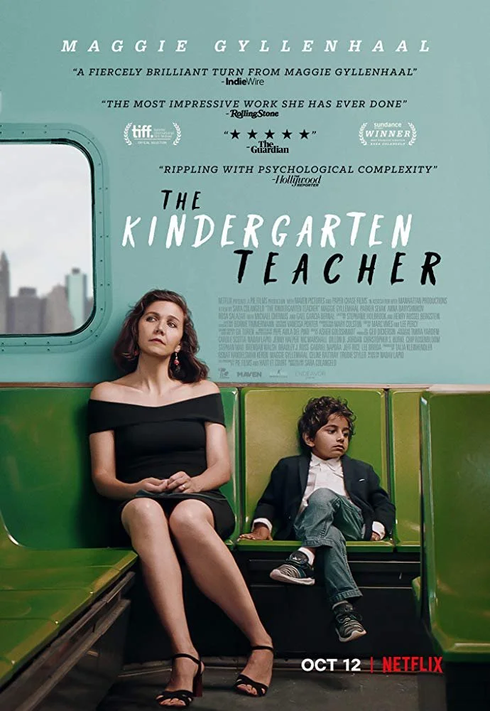 A woman in a black off-shoulder dress and black heels sitting on a green bench with a young boy in a black blazer, white shirt, and jeans sitting next to her inside a subway train. The movie poster for 'The Kindergarten Teacher' is behind them, with titles and reviews at the top and bottom, and the Netflix logo with release date October 12 in the lower corner.