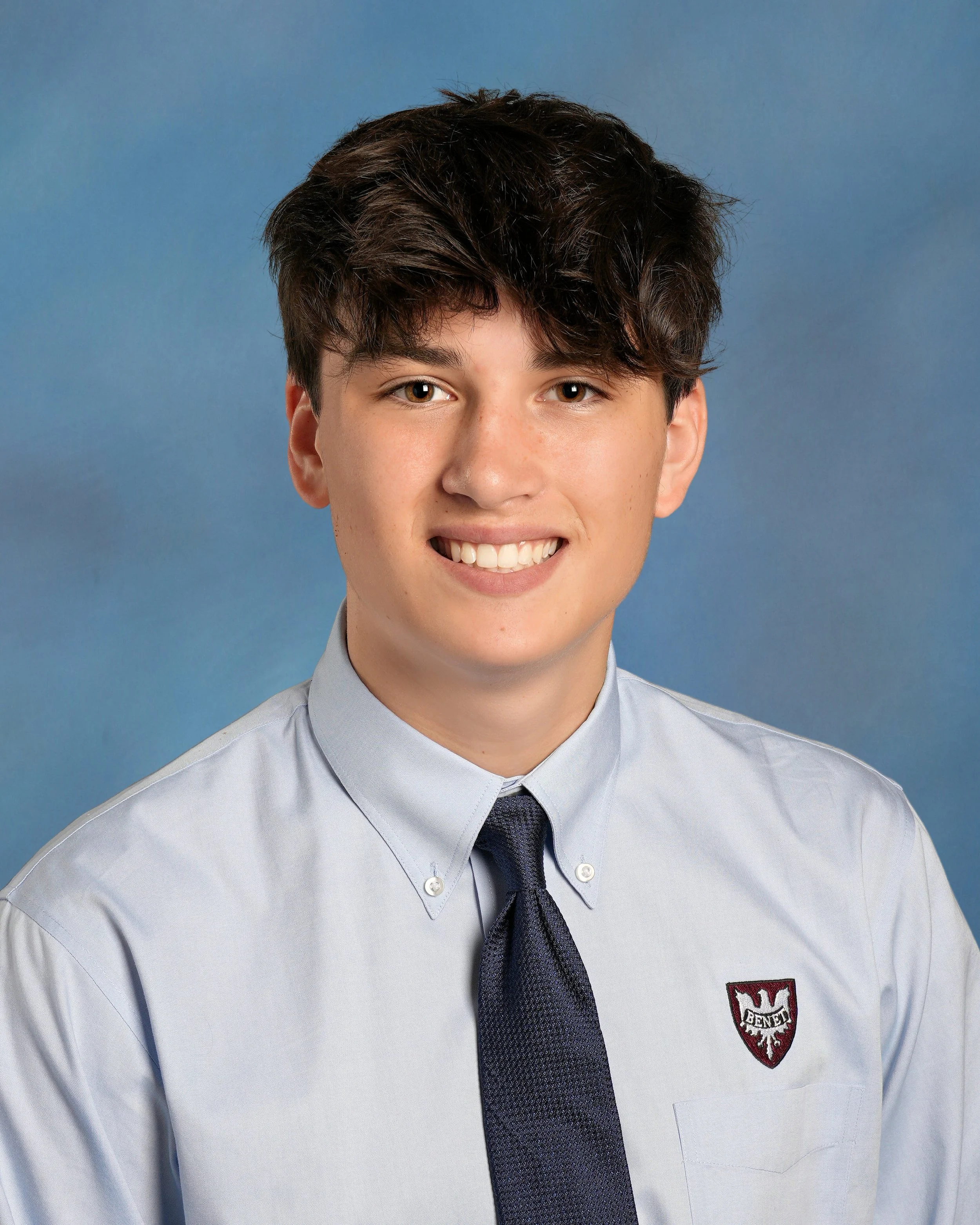Silhouette of a man with short hair, facing forward, with a bright light behind him creating a halo effect.