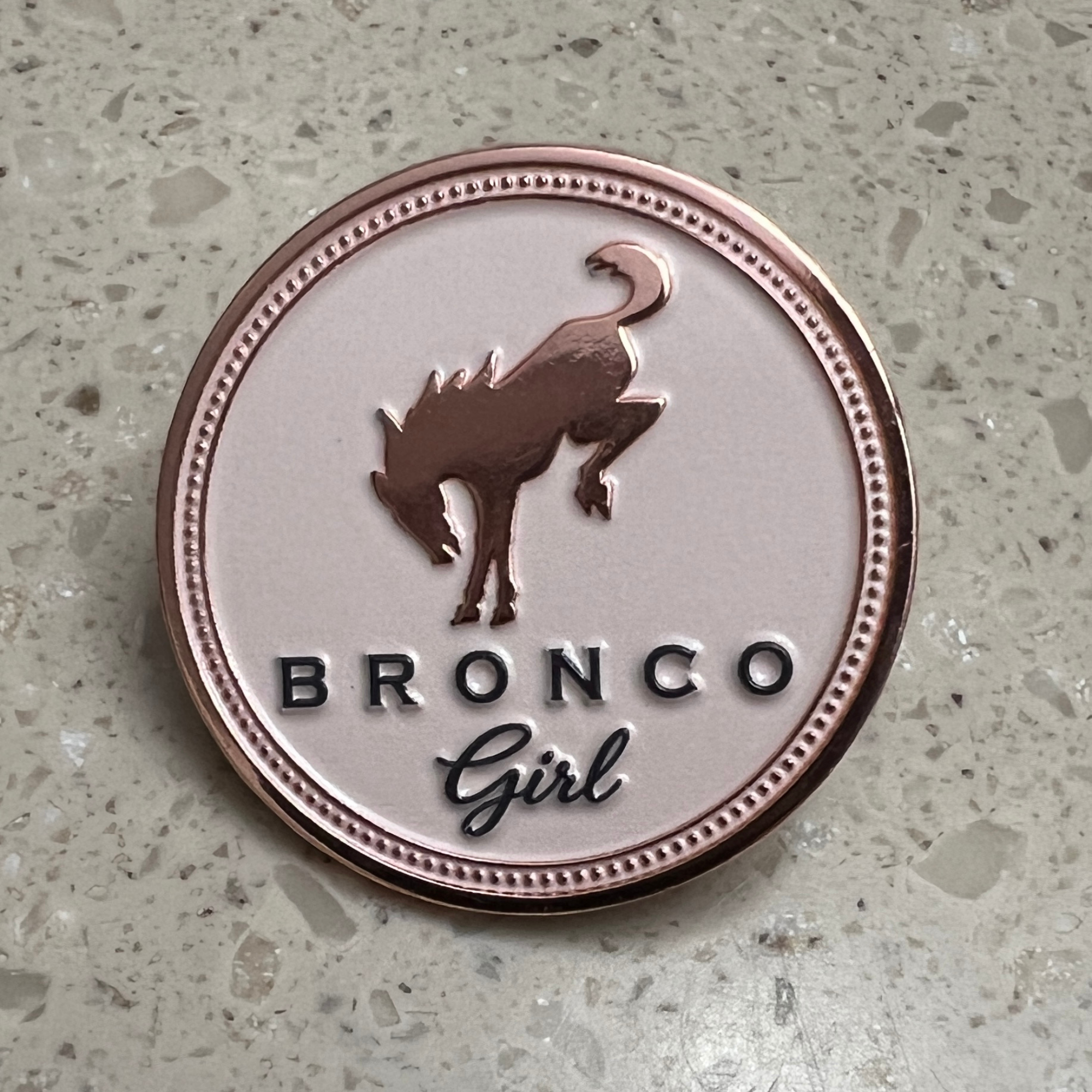 Bronco Girl rose gold soft enamel pin featuring the iconic bucking horse logo on a blush enamel background.