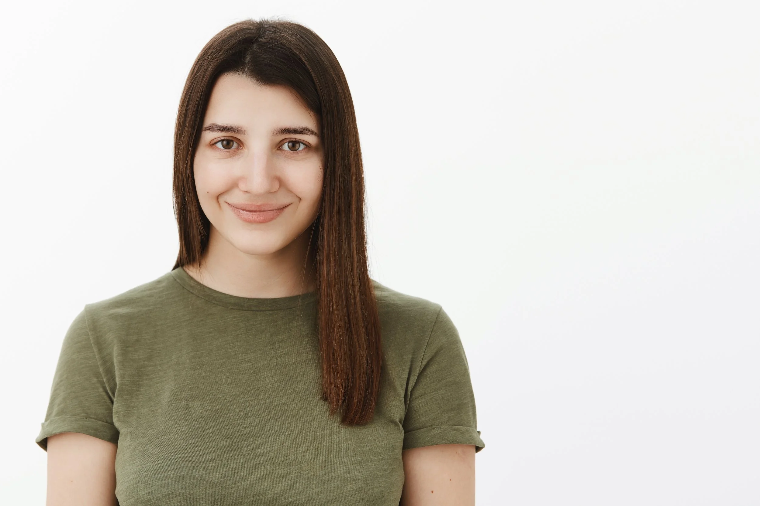Young woman with shoulder-length brown hair smiling, wearing a green t-shirt, standing against a plain white background.