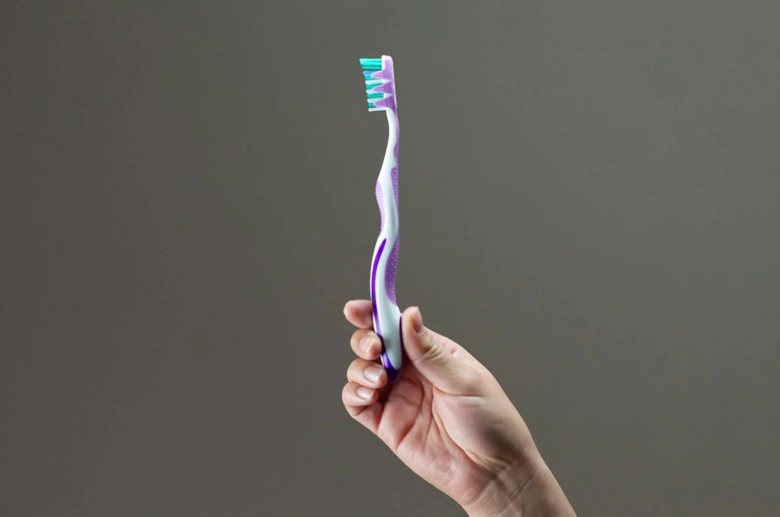 A plastic toothbrush with rubber ergonomic grips