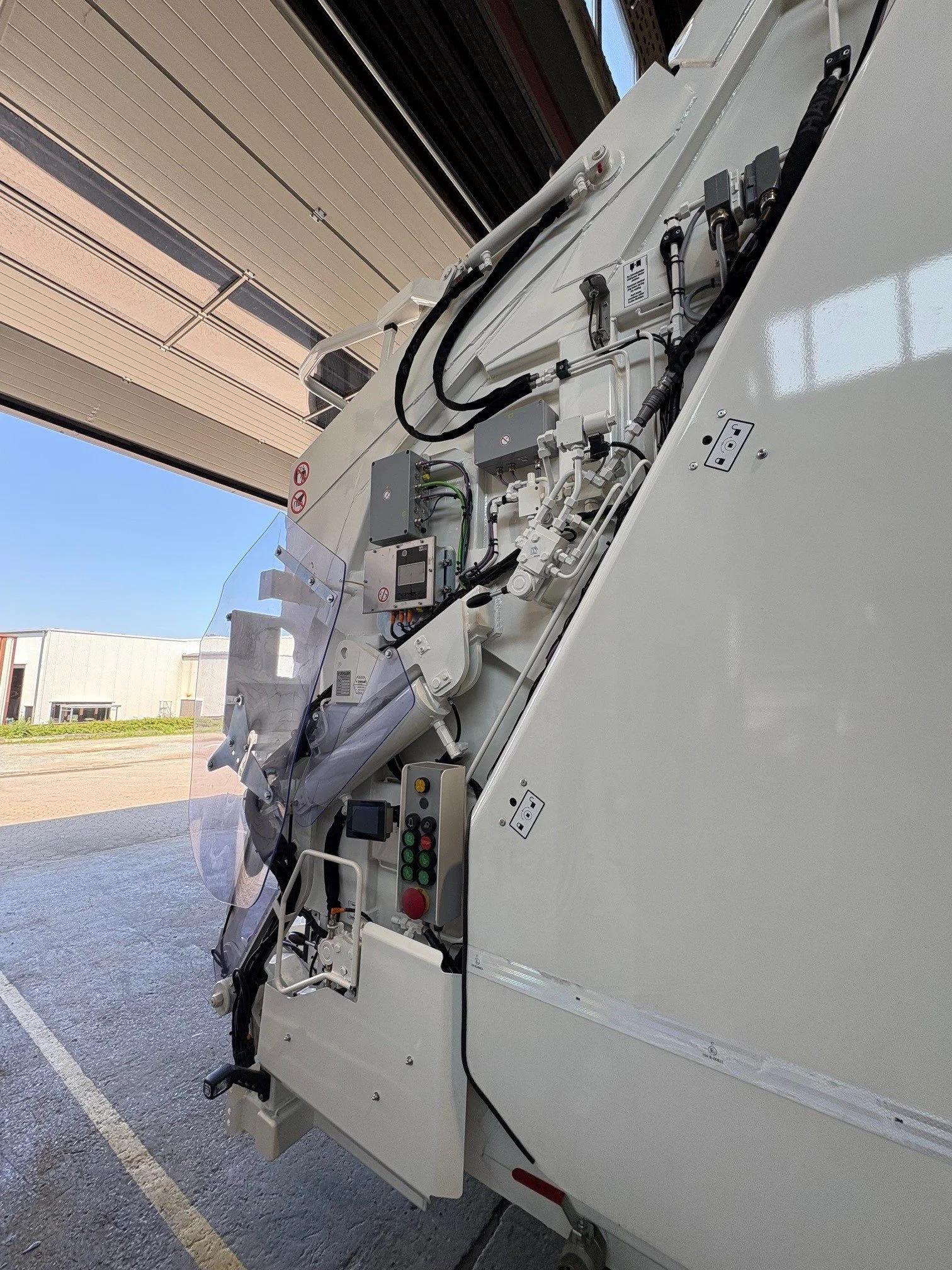 Nahaufnahme einer Kran- oder Baumaschine im Hangar mit Sicht auf elektronische Steuerung und Hydraulikkomponenten.