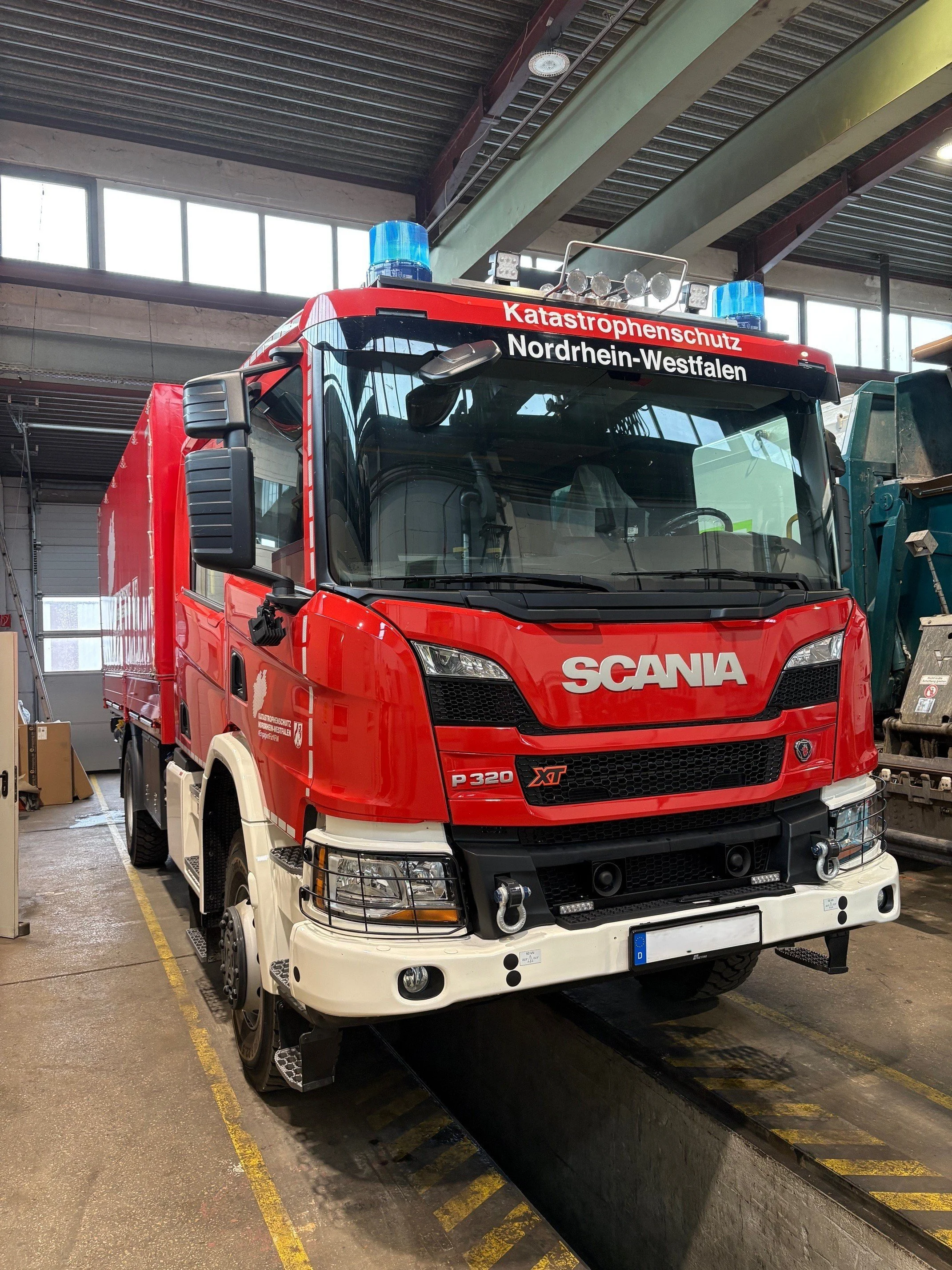 Feuerwehrfahrzeug der Feuerwehr Nordrhein-Westfalen im Einsatz, rot mit blauer Warnleuchte auf dem Dach, im Feuerwehrdepot.