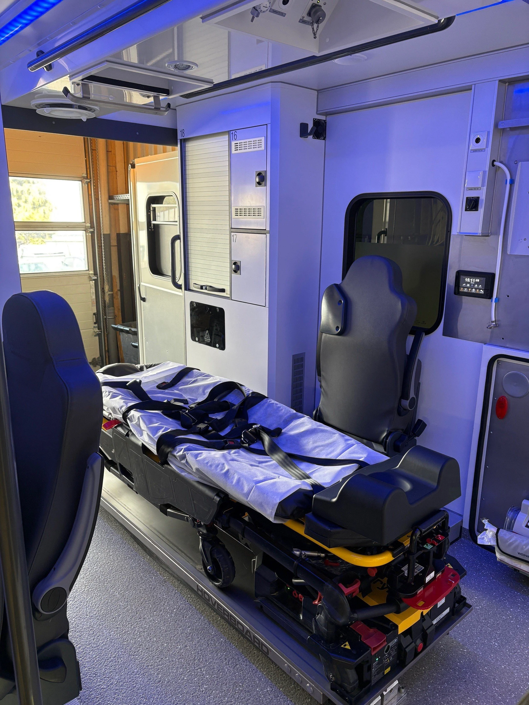 Innenraum eines Rettungswagens mit einer Tragbahre und medizinischer Ausrüstung.