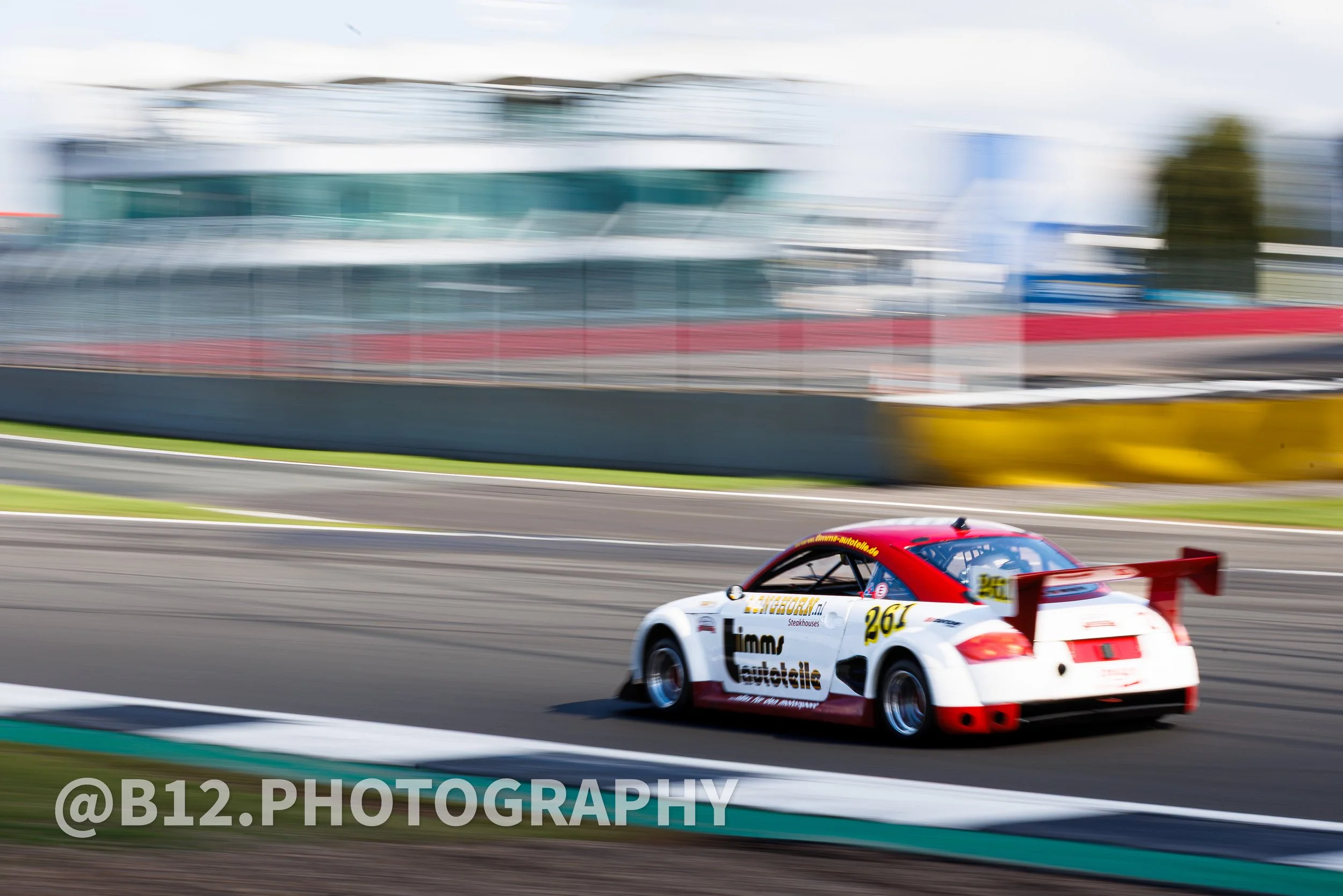 A race car moving on a racetrack with a blurred background, indicating high speed.
