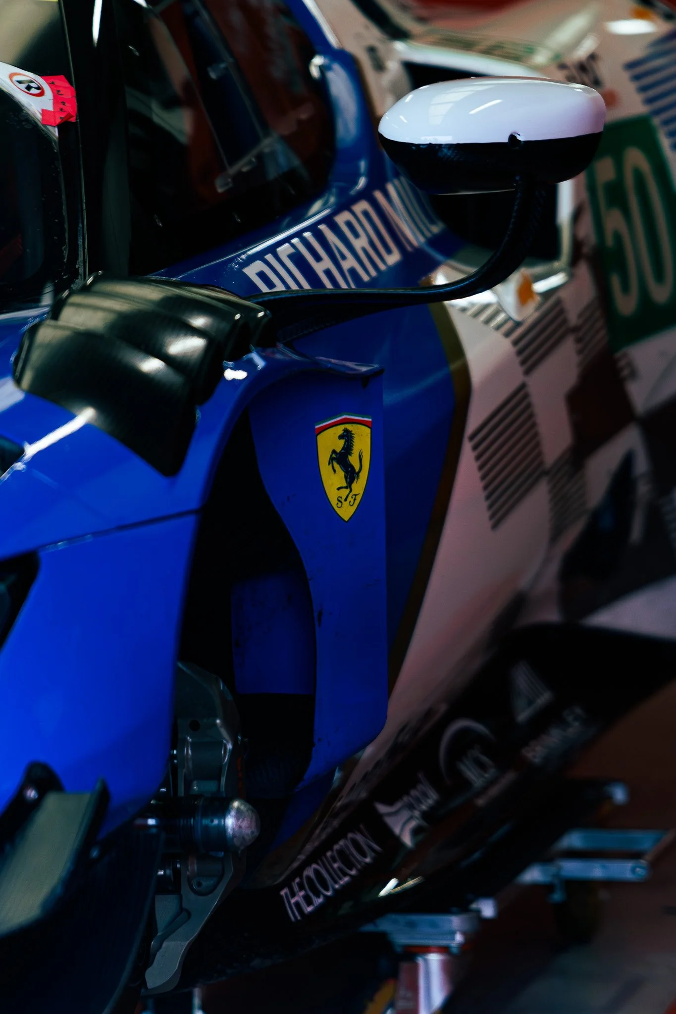 Close-up of a Ferrari Formula 1 race car with the Ferrari logo, various sponsor logos, and a blue and white color scheme.