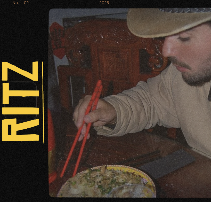 Un homme mangeant un plat avec des baguettes, assis à une table en bois, avec un décor de mobilier en bois sculpté en arrière-plan.