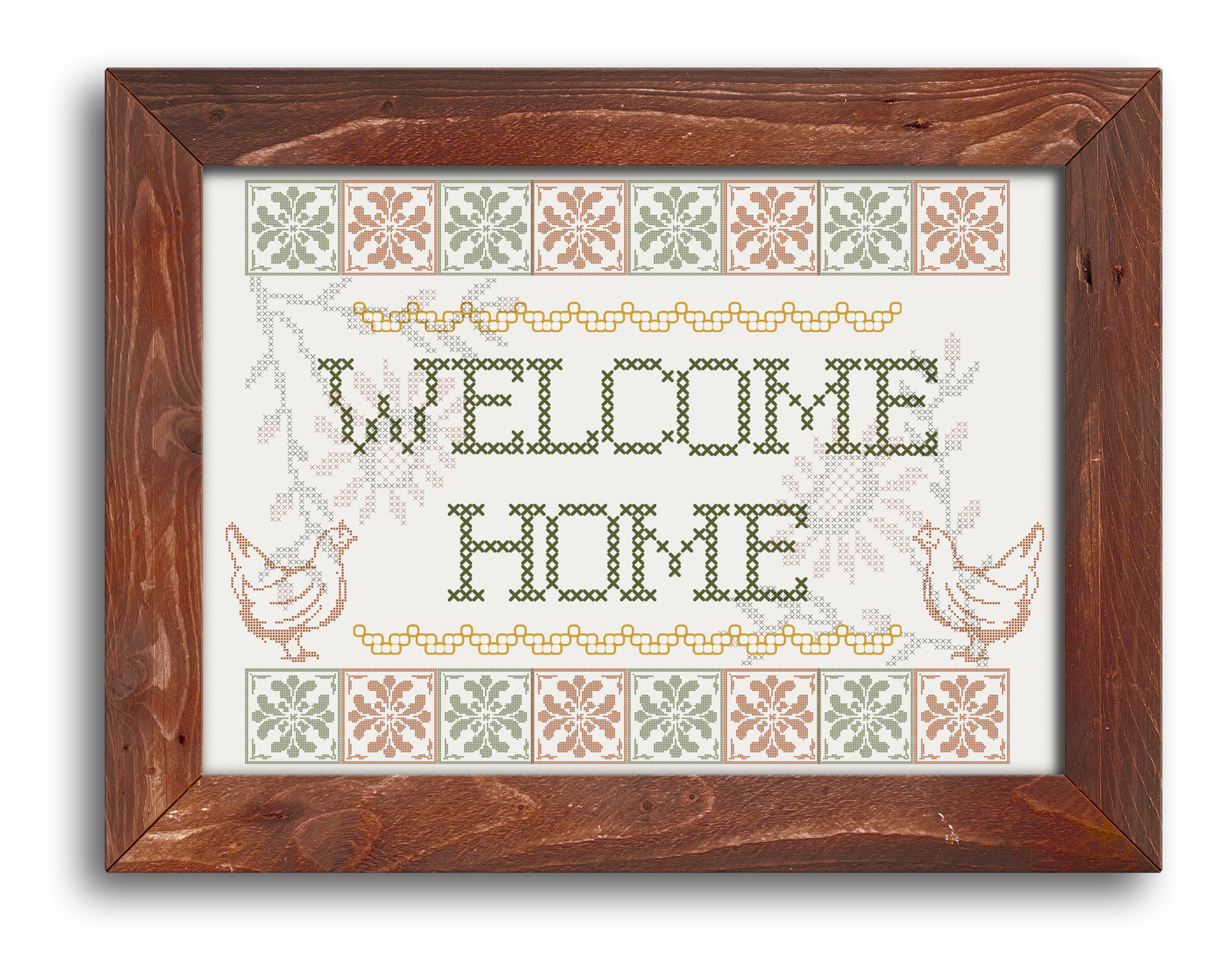 Cross-stitch pattern of the word "WELCOME" in green, decorated with floral and leaf designs, framed in a wooden picture frame.