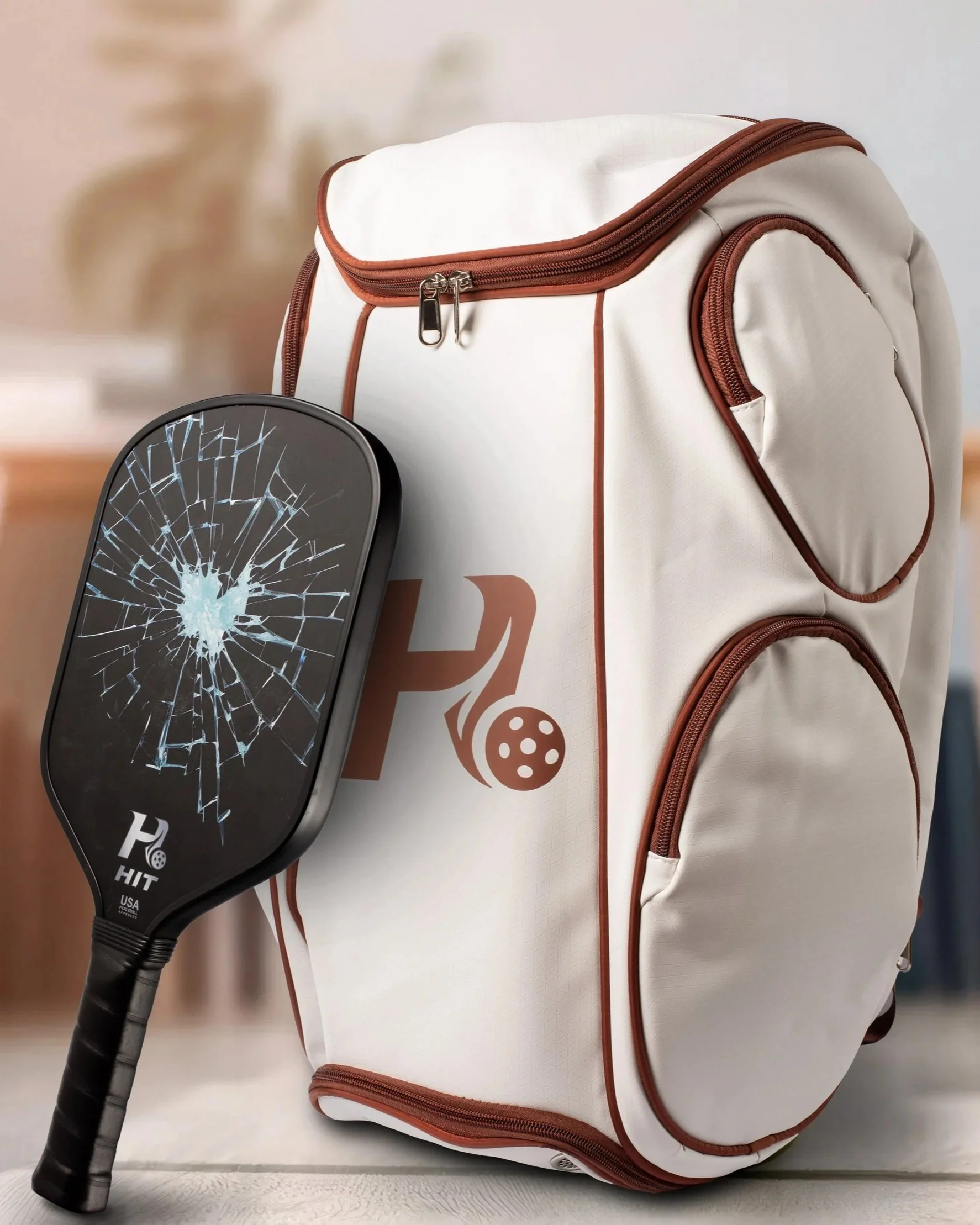 Une raquette de pickleball posée à côté du meilleur sac de sport blanc avec des poches zippées marron.