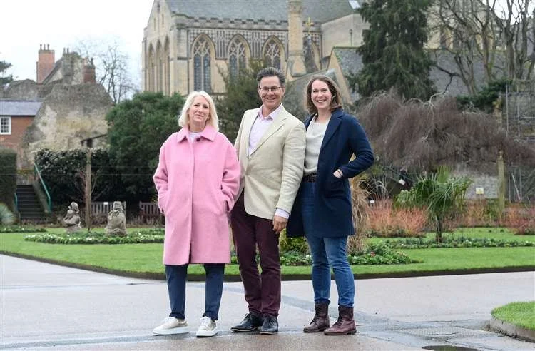 Photo of the Thriving Life Consultancy team. Helen Davies on left, Dr Paul Molyneux in the middle and Gina Suddaby on the right. They are standing in a park in front of Bury St Edmunds cathedral