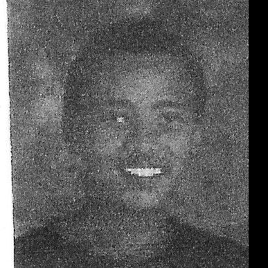 Black and white photo of a young man smiling at the camera.