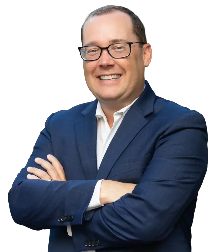 Steve Abreu of Abreu Karol Trademark Law in a navy blue suit and glasses smiling with arms crossed.