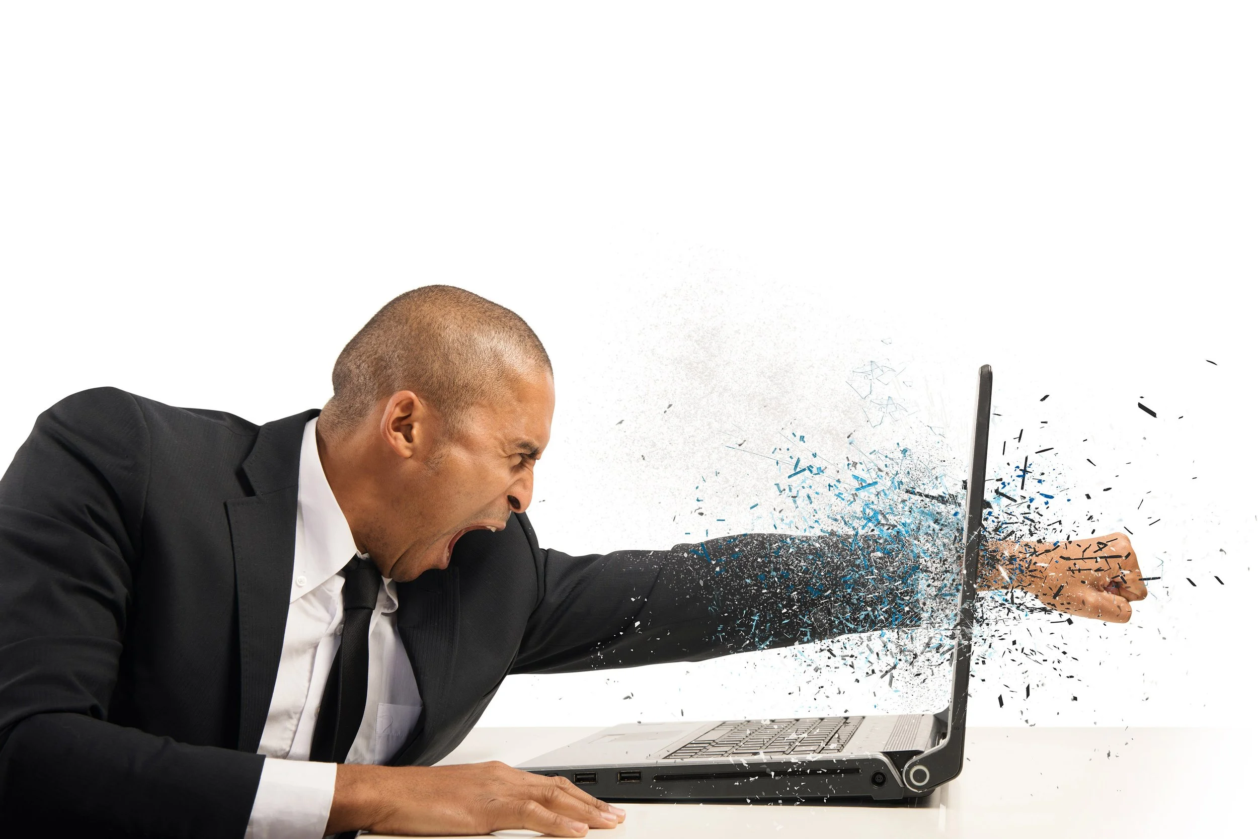 Angry man in business suit with shaved head smashing a laptop with his head, causing the screen to shatter and debris flying.