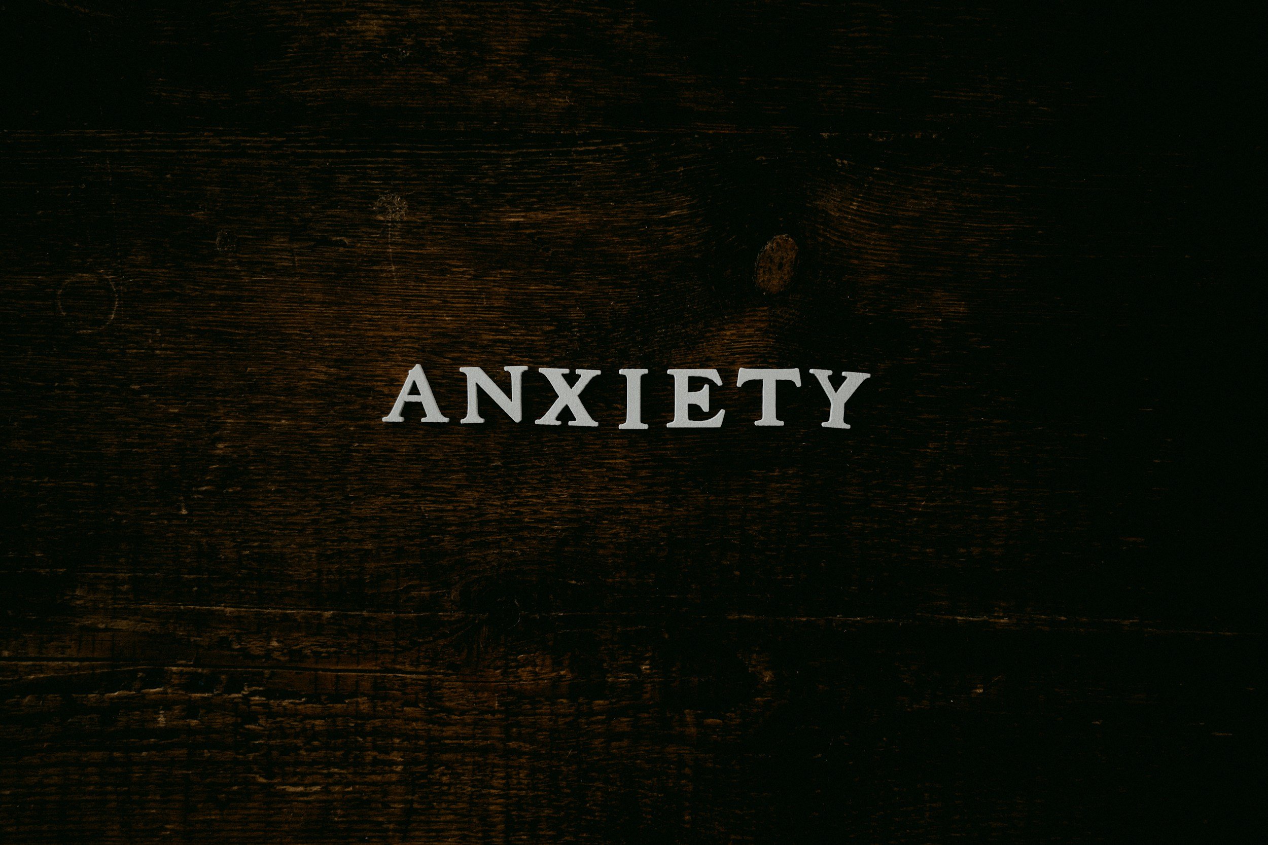 Wooden surface with the word 'ANXIETY' in white capital letters.