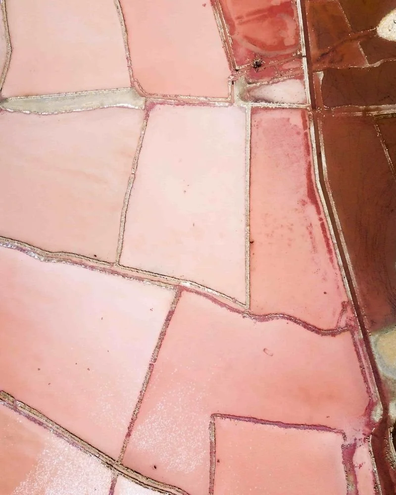 Aerial view of salt evaporation ponds with pink and red hues.