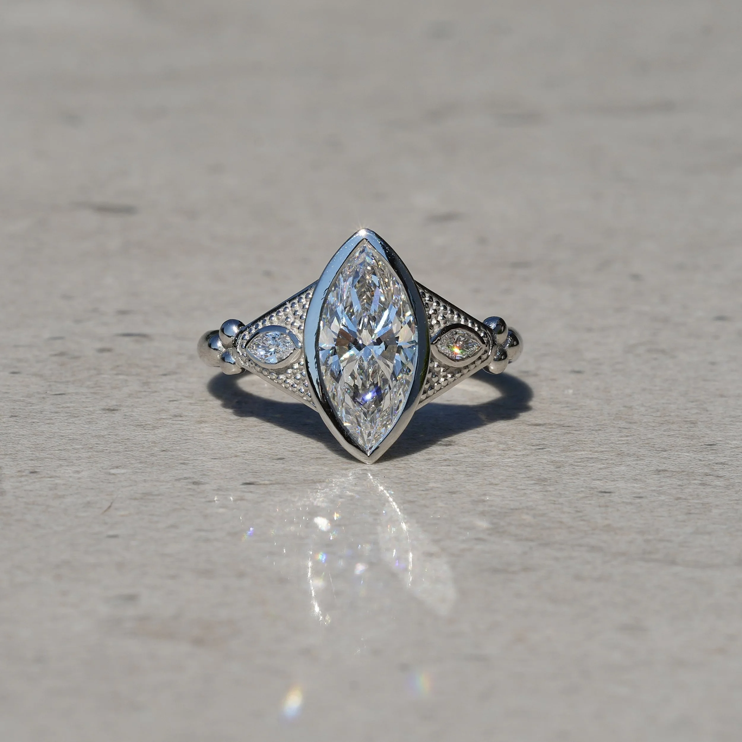 2ct Marquise Bezel Set Diamond Ring with Milgrain with two 0.1ct Side Stones in Platinum, Total 2.2ct – Angeled View | Eighty8Diamonds