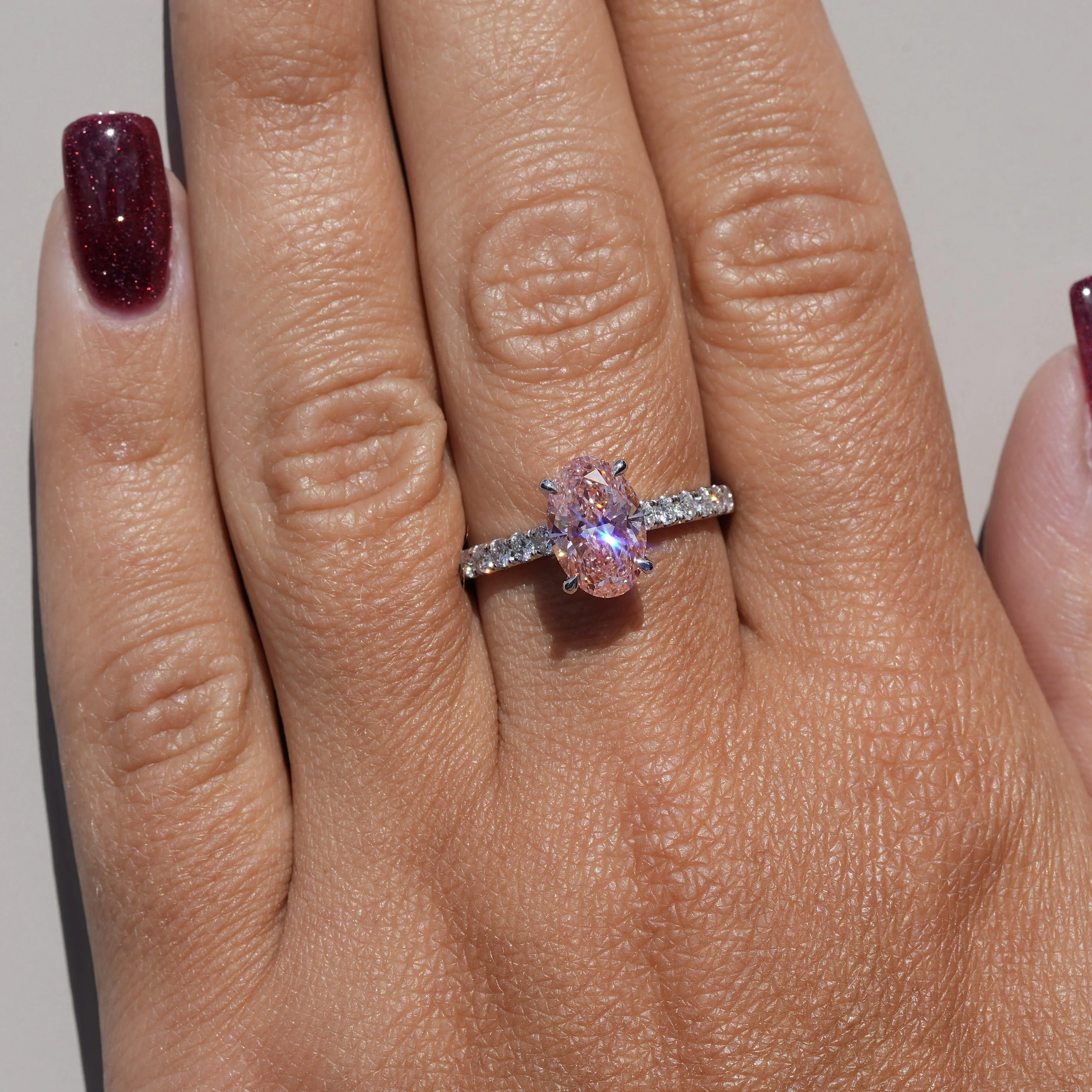 2ct Fancy Vivid Pink Oval Cut Diamond Engagement Ring with Diamond Band in Platinum –Hand View | Eighty8Diamonds