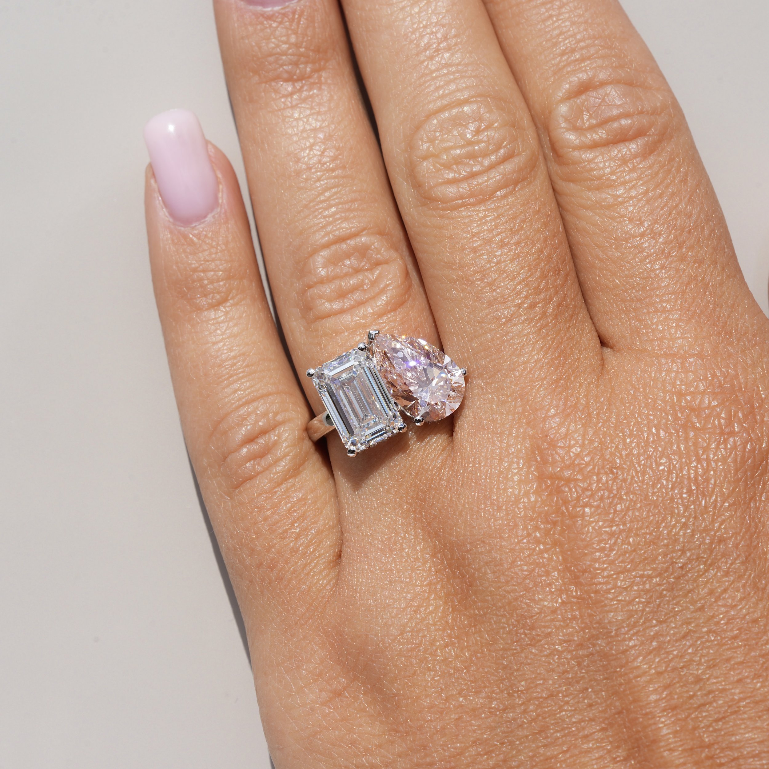 Toi et Moi Ring with 3.5ct Fancy Vivid Pink Pear Cut Diamond and 4.0ct Emerald Cut Diamond with Hidden Halo in Platinum, Total Carat Weight 7.70ct – Hand View | Eighty8Diamonds