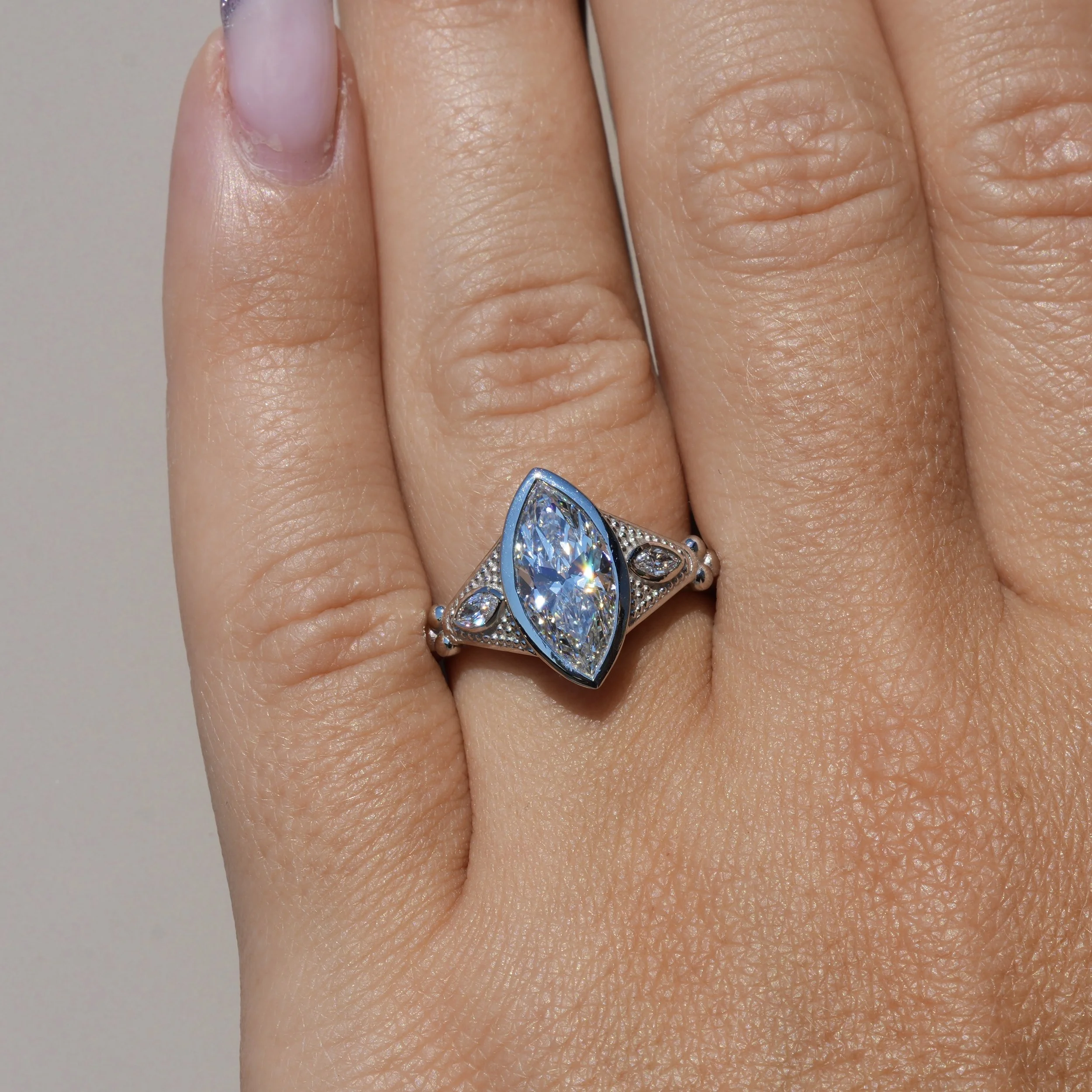 2ct Marquise Bezel Set Diamond Ring with Milgrain with two 0.1ct Side Stones in Platinum, Total 2.2ct – Hand View | Eighty8Diamonds
