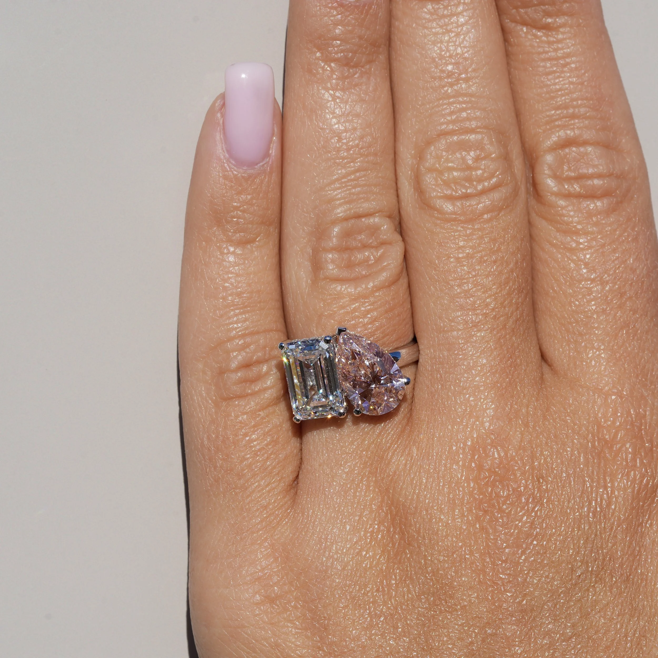 Toi et Moi Ring with 3.5ct Fancy Vivid Pink Pear Cut Diamond and 4.0ct Emerald Cut Diamond with Hidden Halo in Platinum, Total Carat Weight 7.70ct – Hand View | Eighty8Diamonds