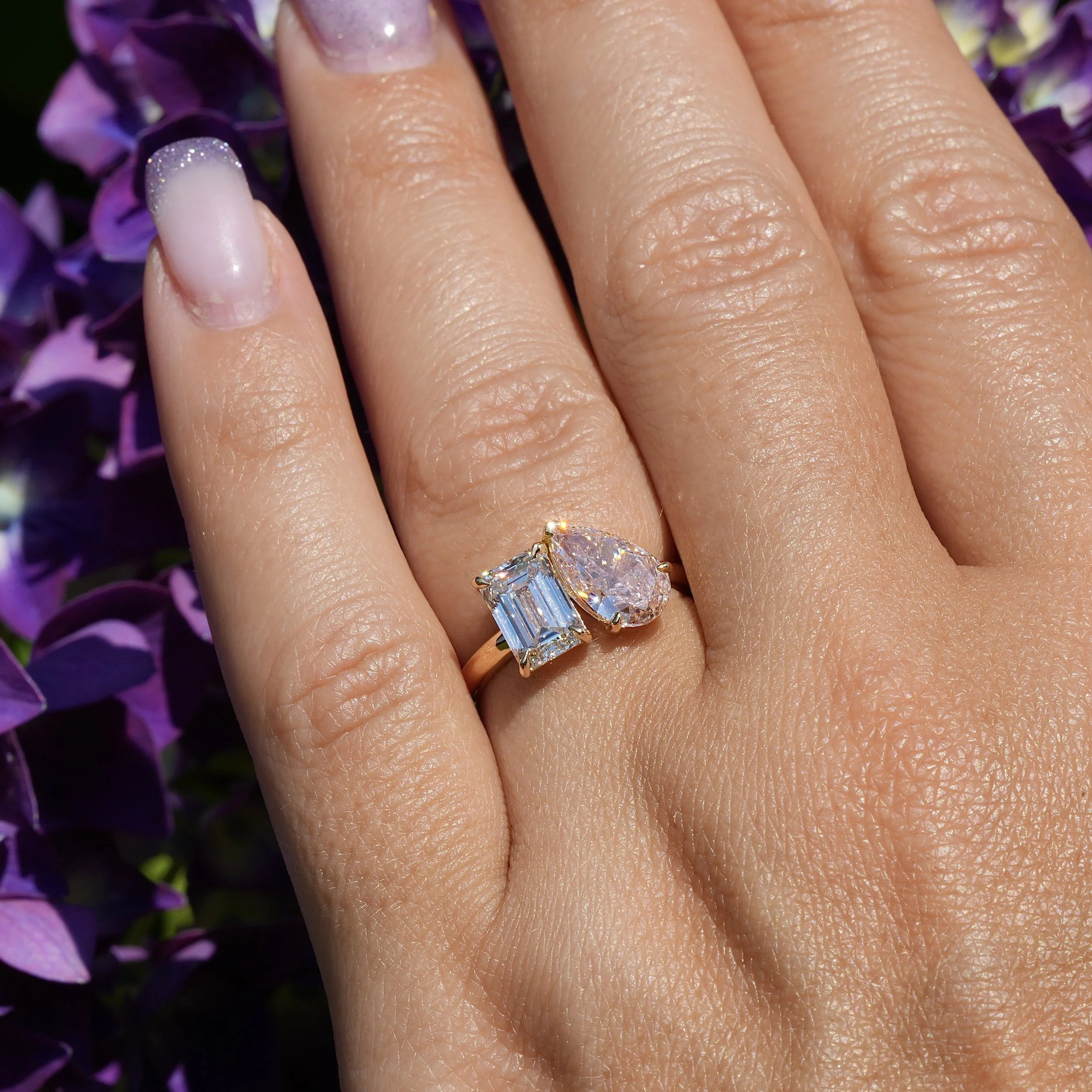 Toi et Moi Ring with 1.5ct Fancy Intense Pink Pear Cut Diamond and 1.5ct Emerald Cut Diamond in 18ct Yellow Gold, Total Carat Weight 3ct – Hand View | Eighty8Diamonds