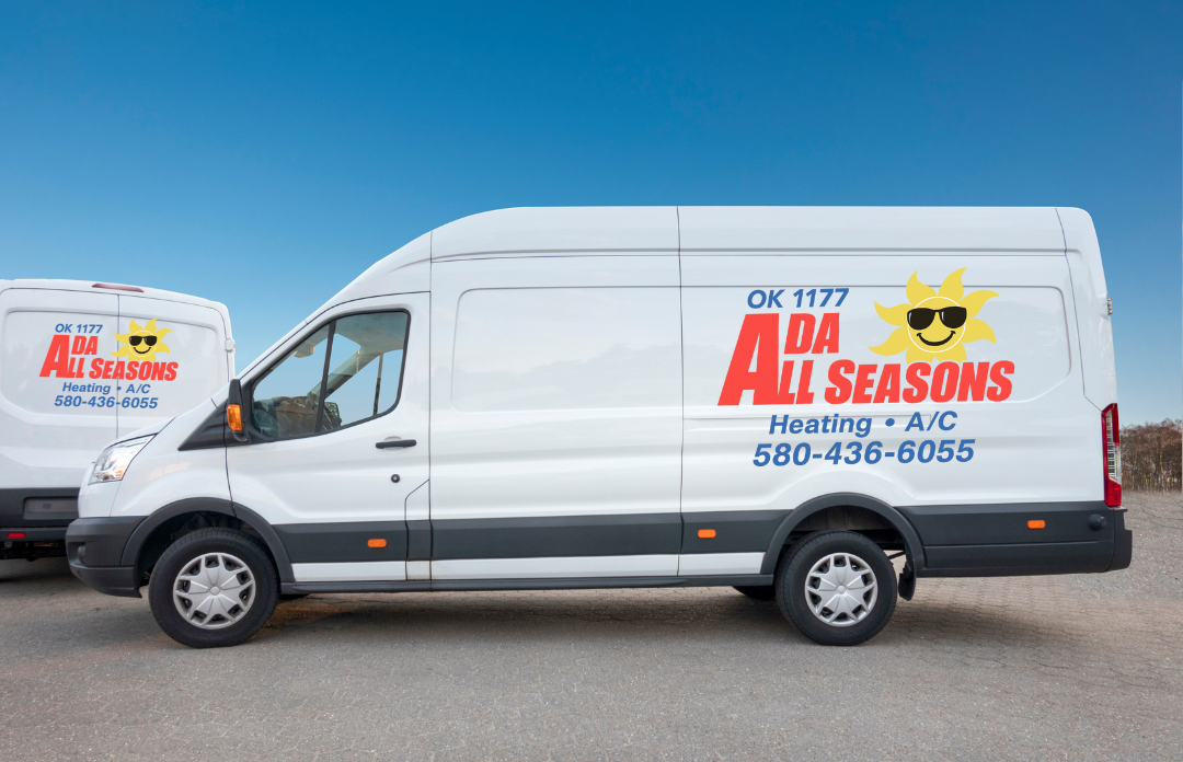 A white commercial van with the logo of ADA All Seasons heating and air conditioning company, featuring a smiling sun wearing sunglasses, parked outdoors under a blue sky.