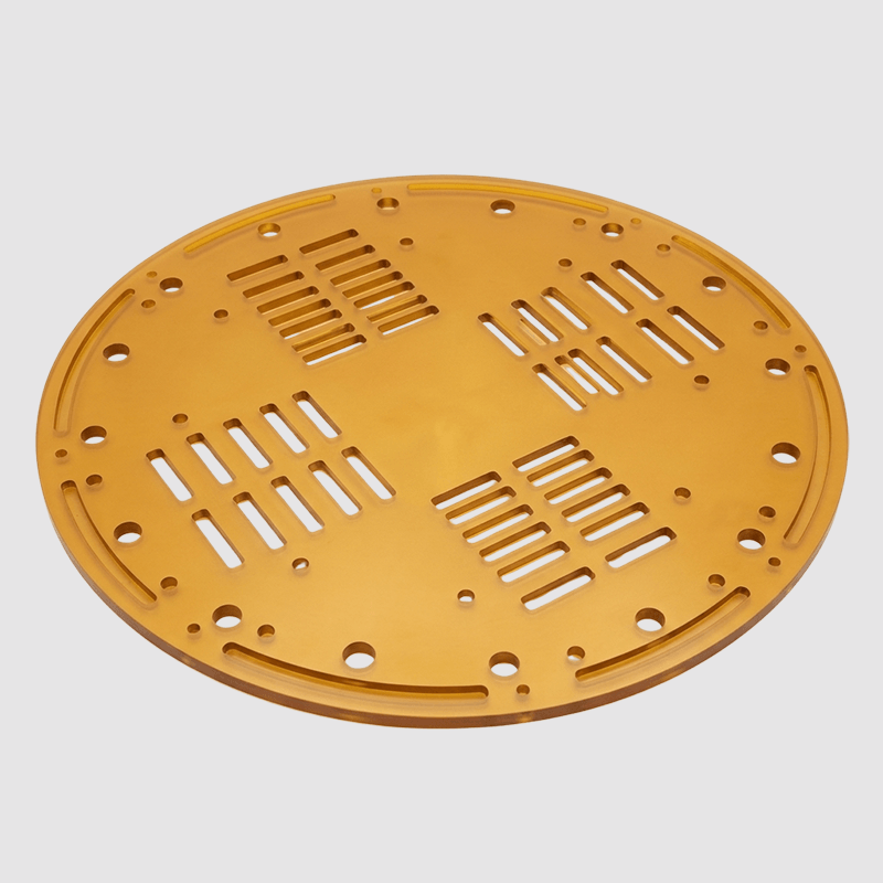A circular yellow plastic object with multiple rectangular and circular cutouts, possibly a component or cover for a machine or device.