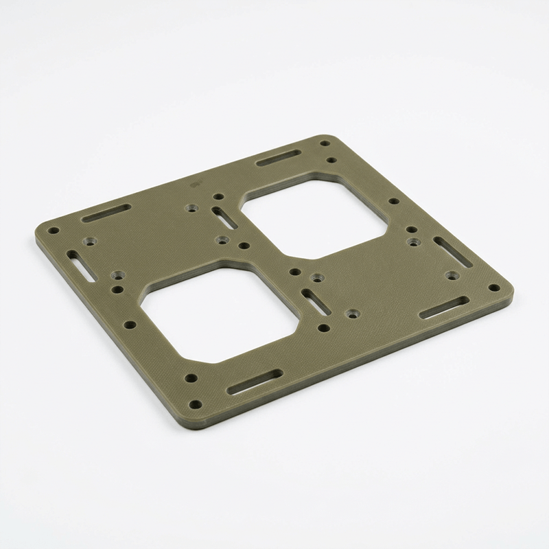 A green plastic or metal mounting bracket with multiple holes and slots, likely for electronic or mechanical components.