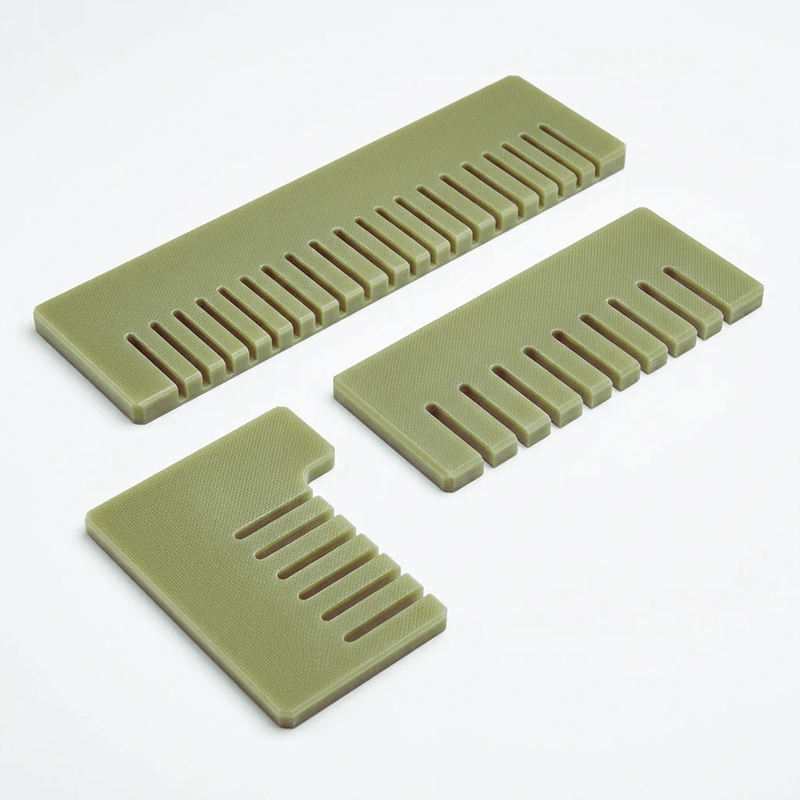 Three green plastic combs of different sizes on a white background.