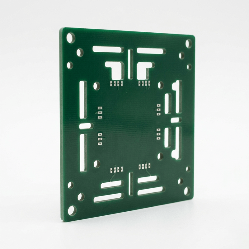 A green printed circuit board with various holes and slots for electronic components, standing upright on a white background.