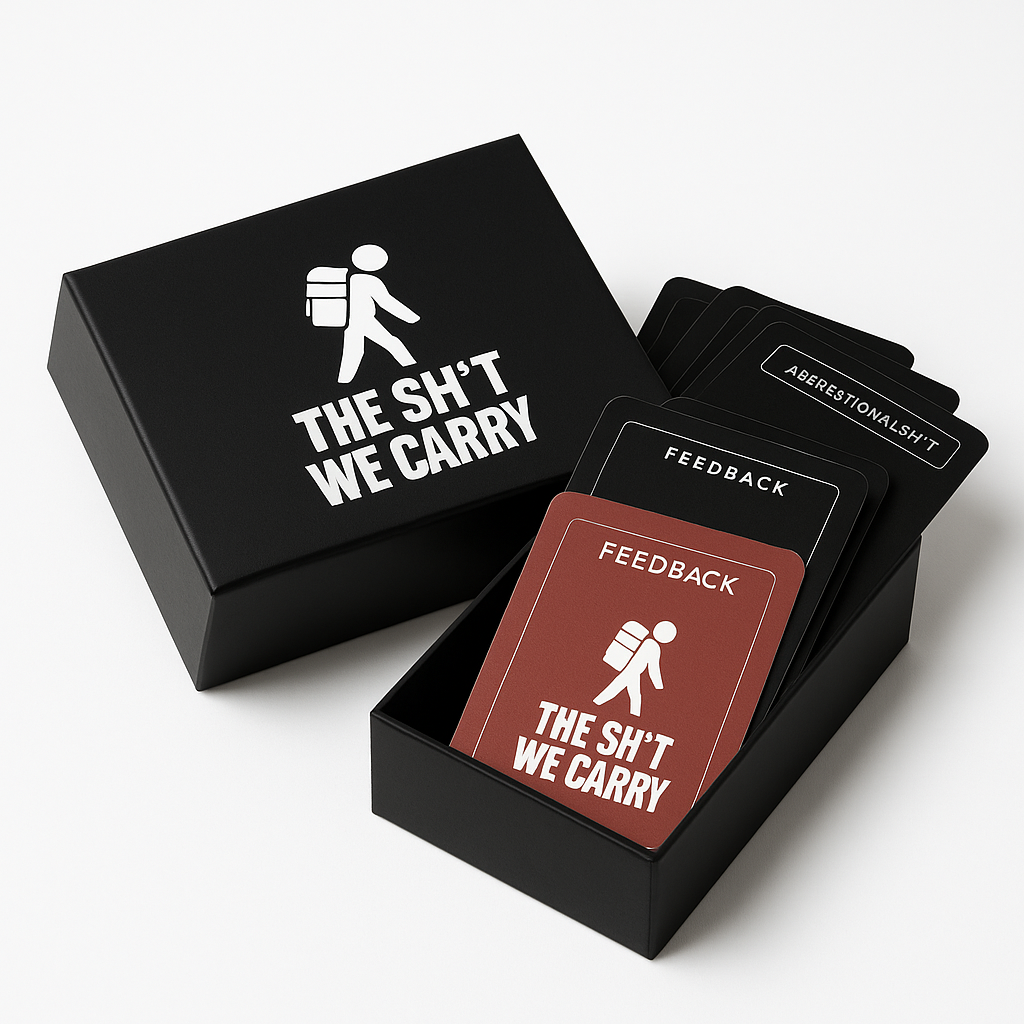 Black box with a lid labeled 'THE SH*T WE CARRY' and a graphic of a person with a backpack, with feedback and aberationalsh*t cards inside.
