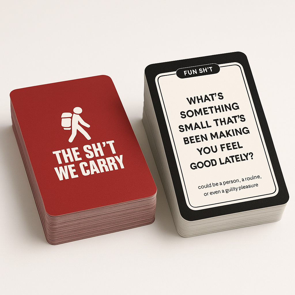 Two stacks of cards, one with a red background and a pedestrian icon, reading "THE SH*T WE CARRY," and the other with a white background and black border, titled "FUN SH*T" and asking "WHAT'S SOMETHING SMALL THAT'S BEEN MAKING YOU FEEL GOOD LATELY?"