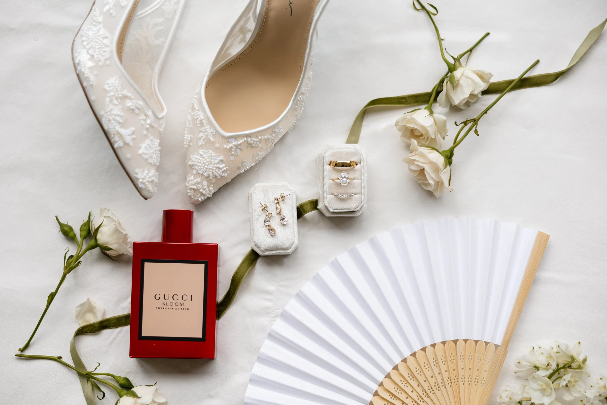An elderly man with a beard dressed in a suit and tie looking through a window, with a smiling bride in a wedding dress and veil visible in the reflection behind him.