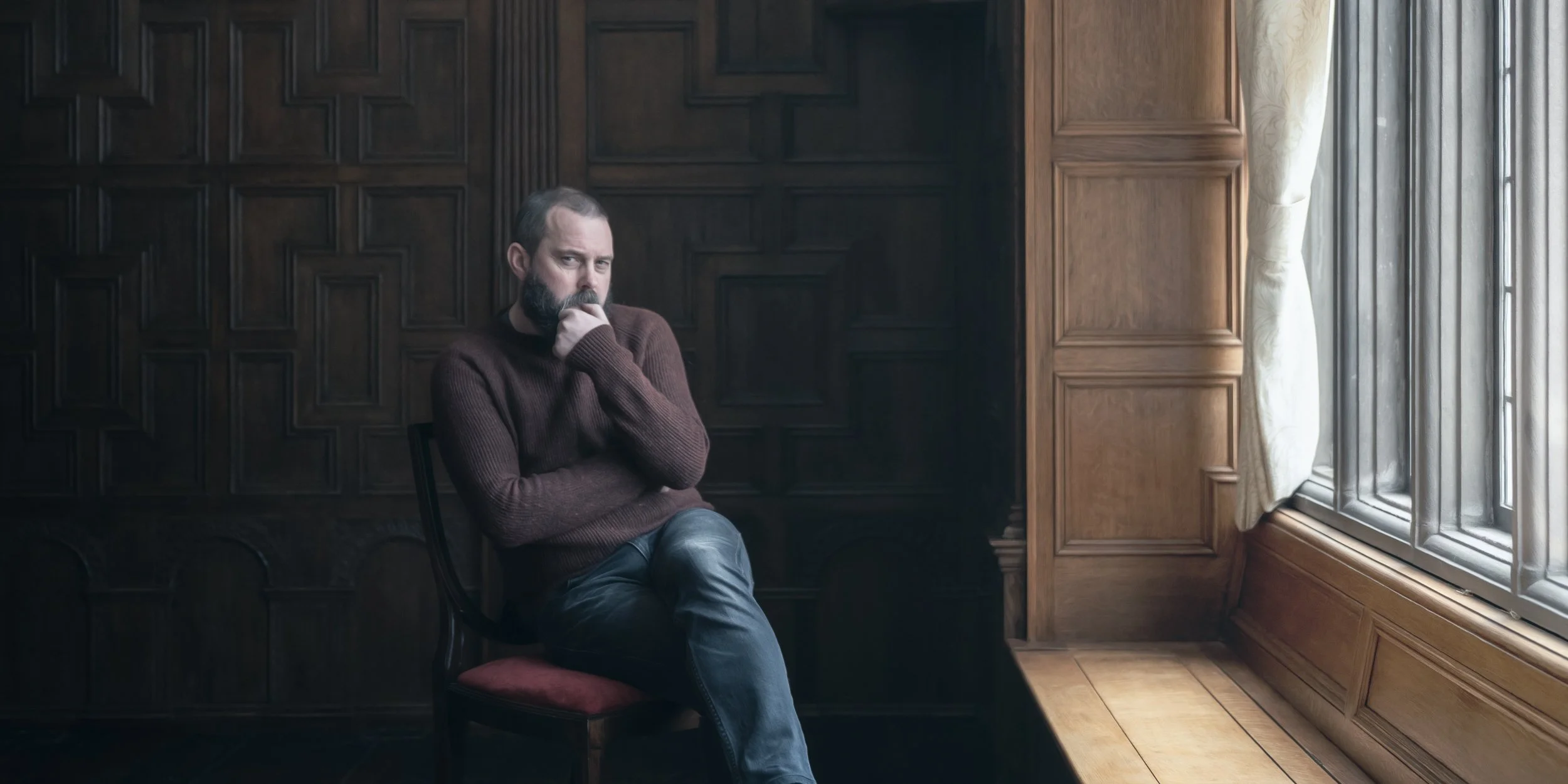 Photographer Pete Wilkinson sitting by a window for a portrait