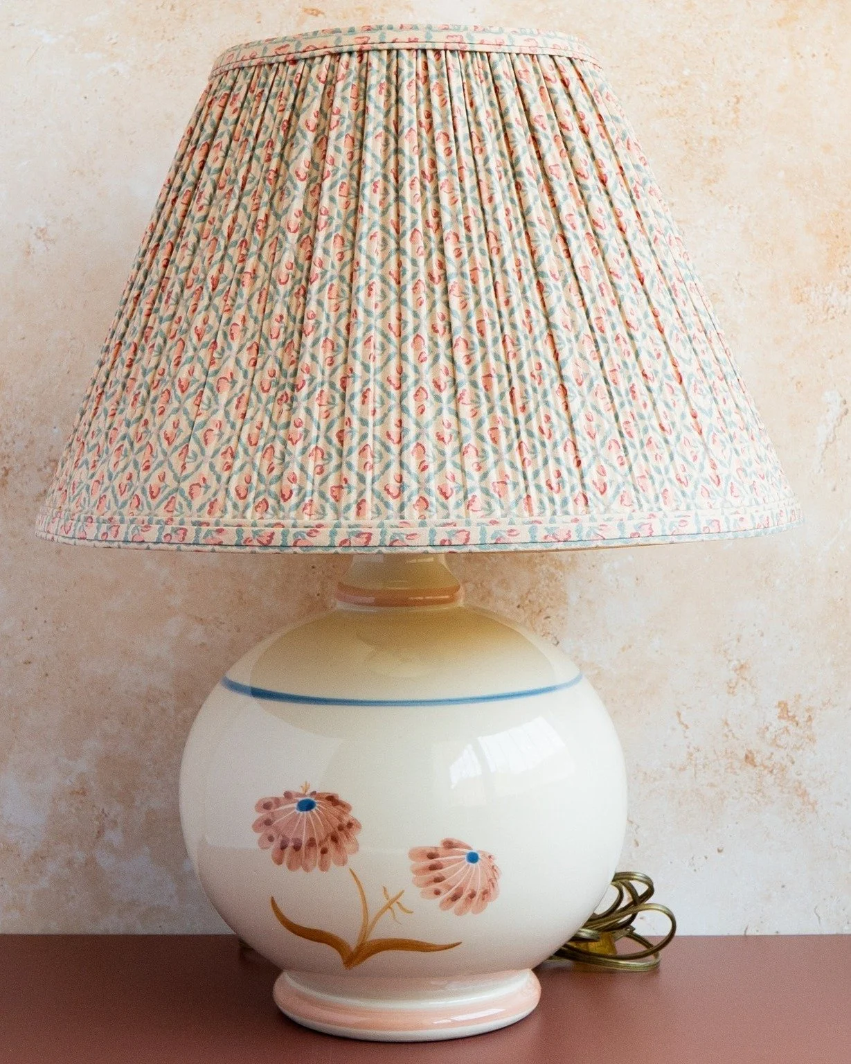 These are definitely one of a kind. They're from the 70s and made by Ethan Allen during their country and early American design era. Hand painted on ceramic with cotton pleated shades. 

The glow they emit is fabulous. 🌟 I've been using them for 2 y