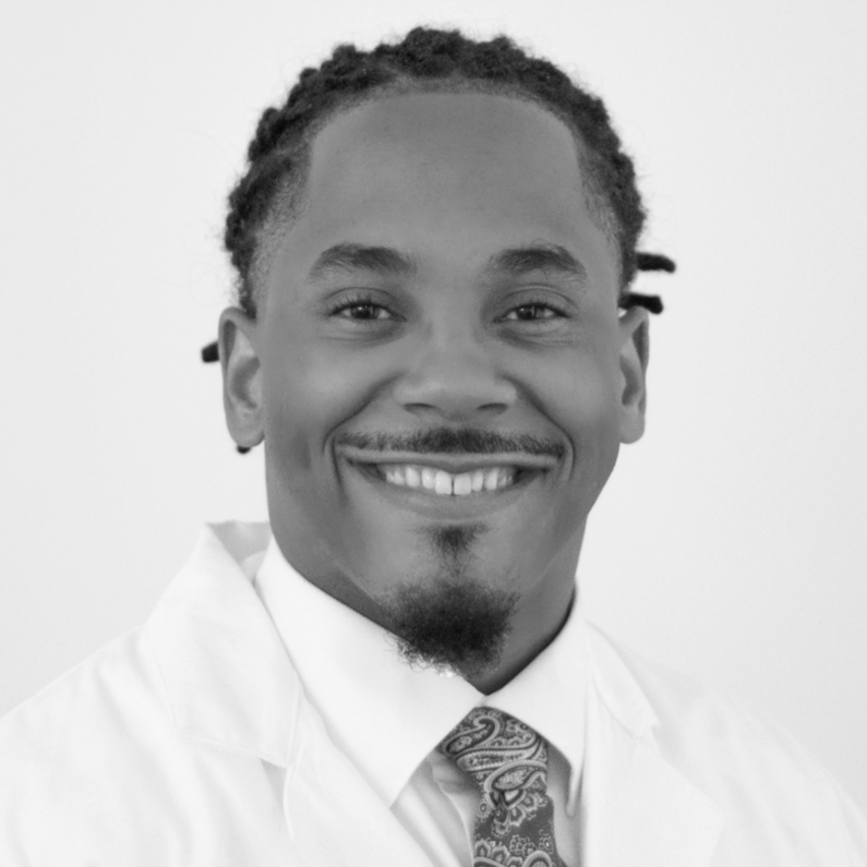 Portrait of a smiling African American wearing a white coat and tie.