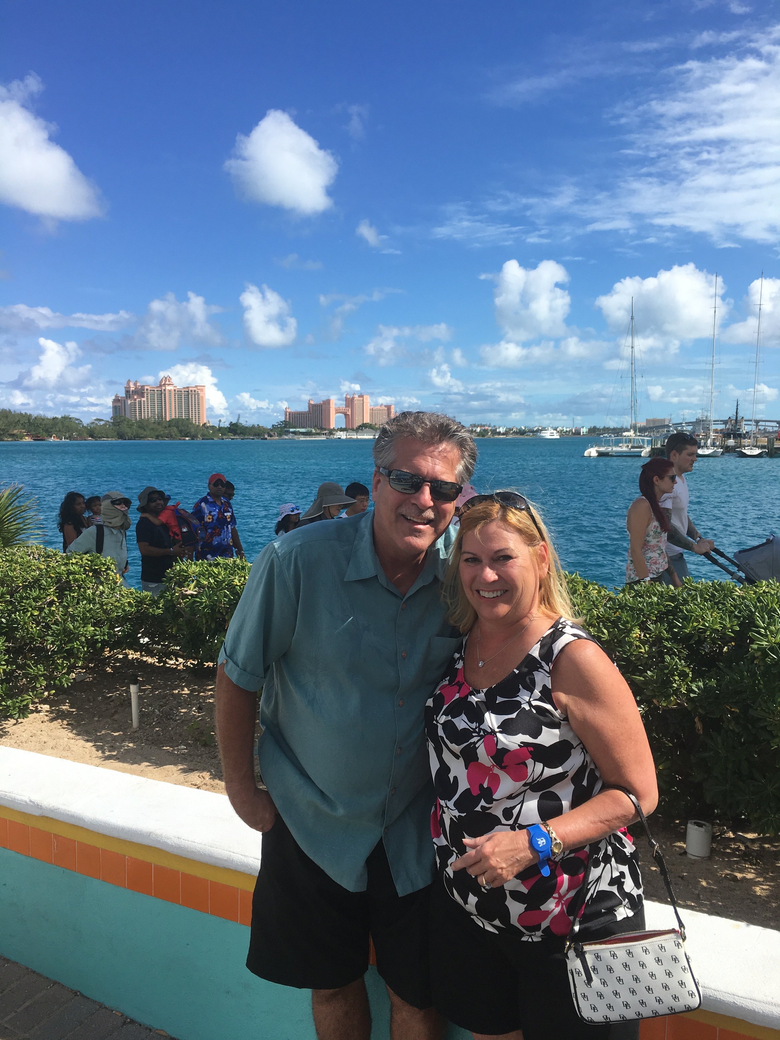 One of our Journeys Travel advisors and her husband in front of an oceanside resort.