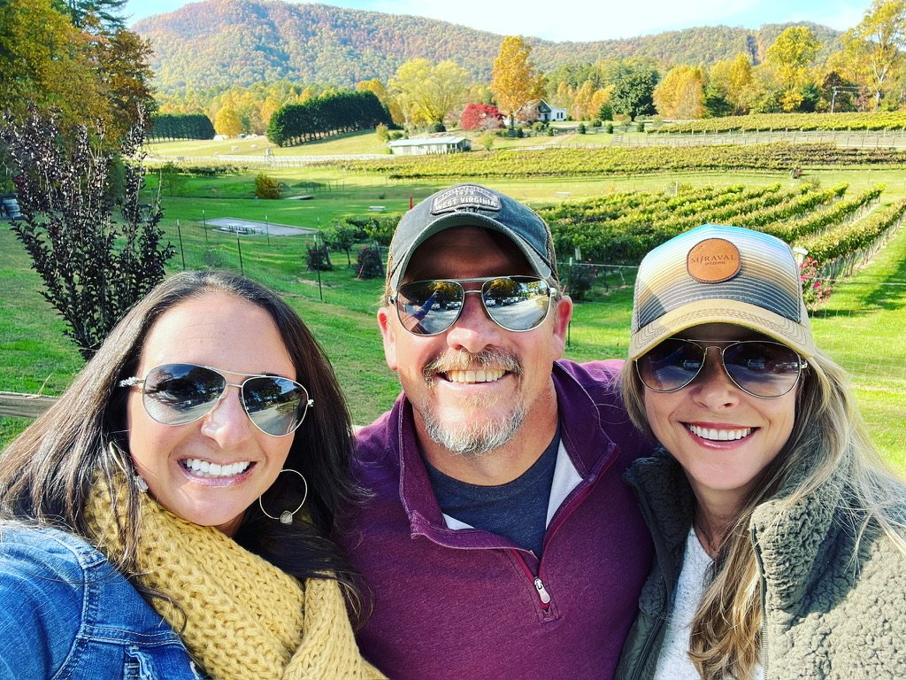 A group of Journeys Travel Advisors in front of a farm landscape.