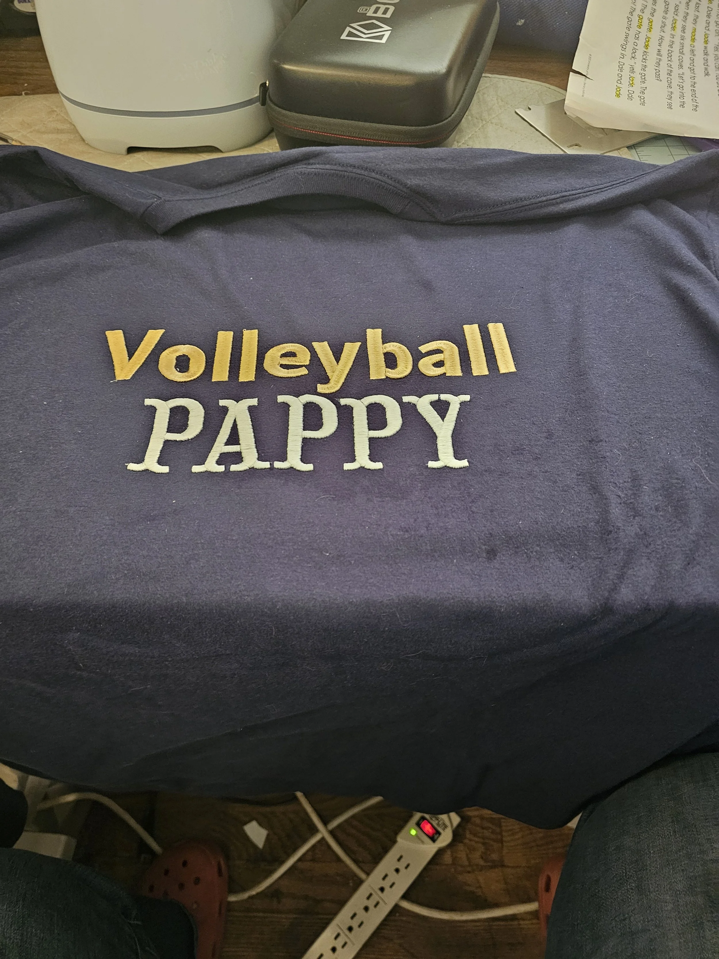 A navy blue bag with yellow and white embroidered text that reads 'Volleyball PAPPY.'