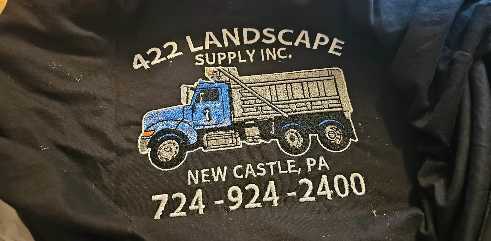 Embroidered logo of 422 Landscape Supply Inc. featuring a blue truck, with the company name, location in New Castle, PA, and phone number.