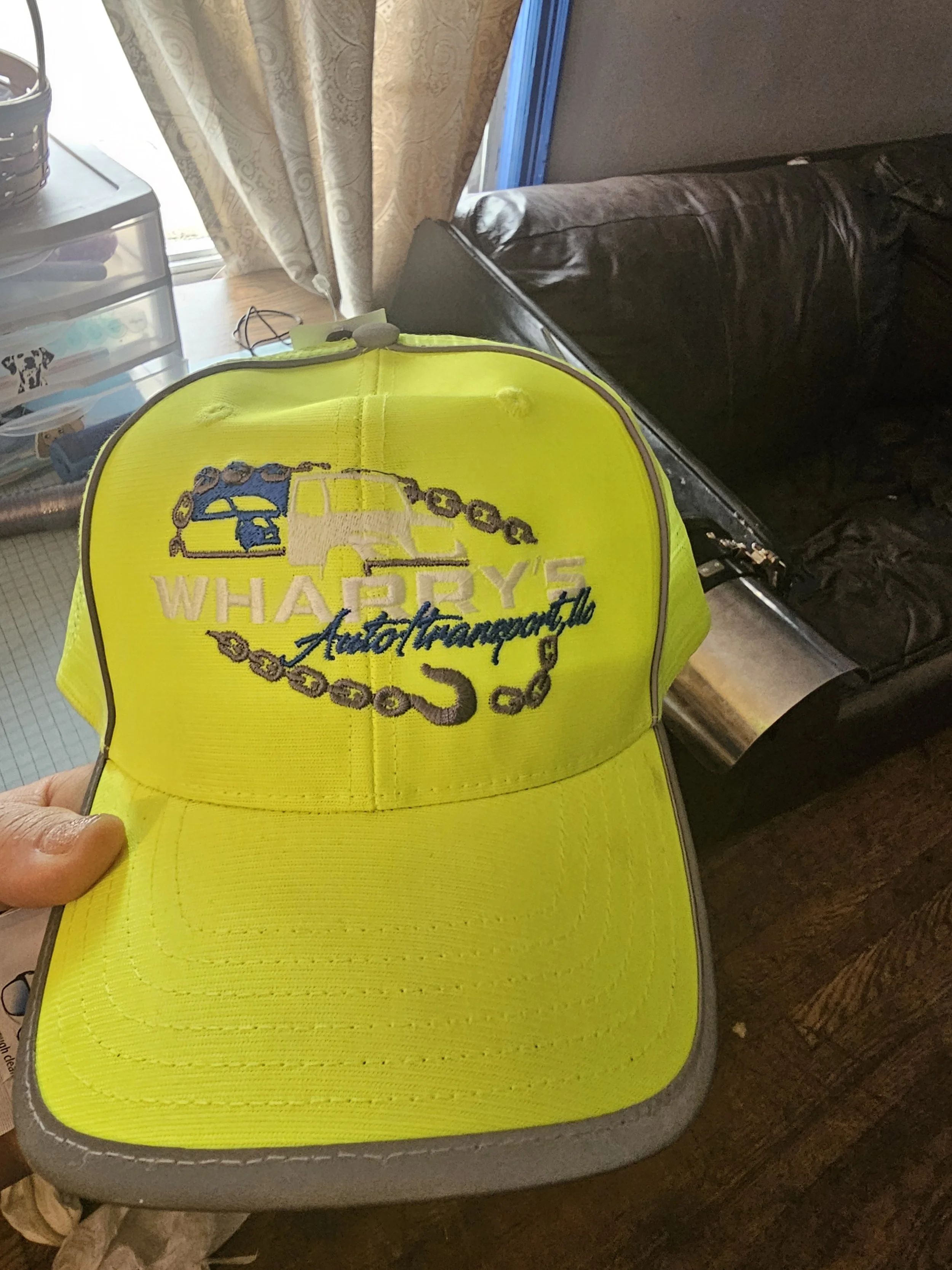 Bright yellow cap with embroidered logo of Warey's Auto Management, featuring a car, a wrench, and a chain design.