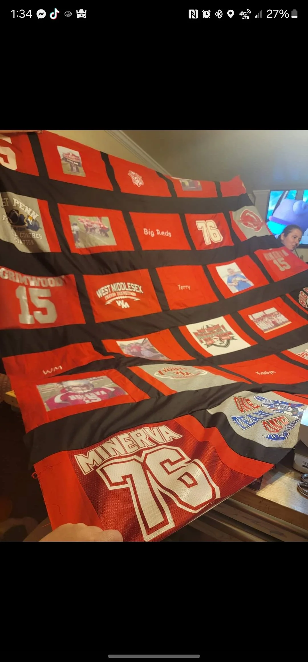 A blanket with a grid of squares featuring images and text related to football teams and players, mainly in red, black, and white colors. The blanket shows team logos, player names, and jersey numbers, including Minerva, Big Reds, 76, and 15.