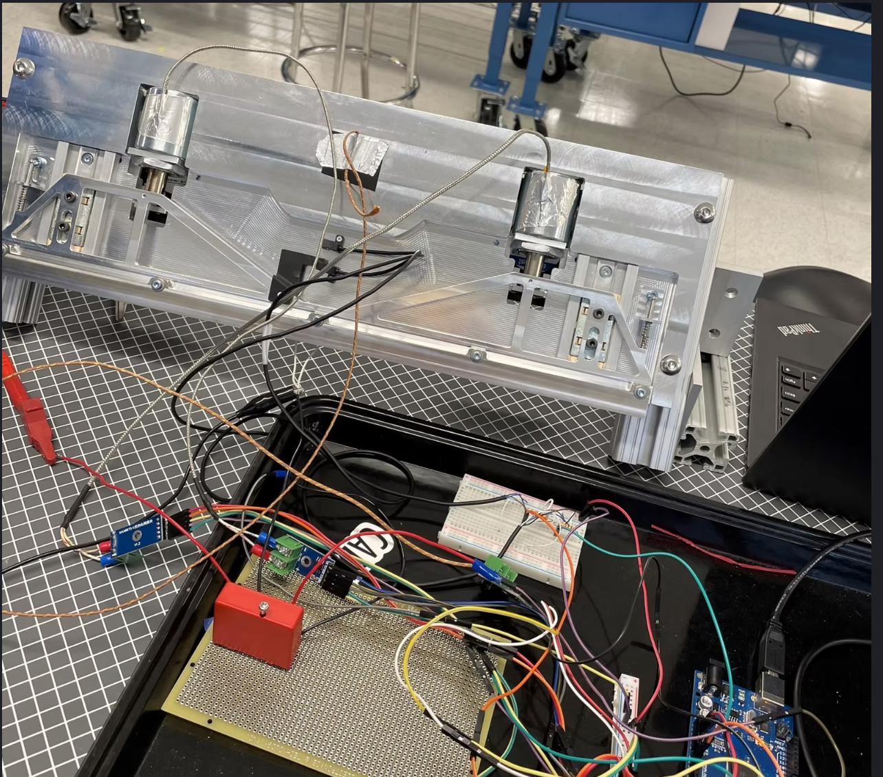 Bench test setup for solenoid shutter timing with sensors and logger visible.