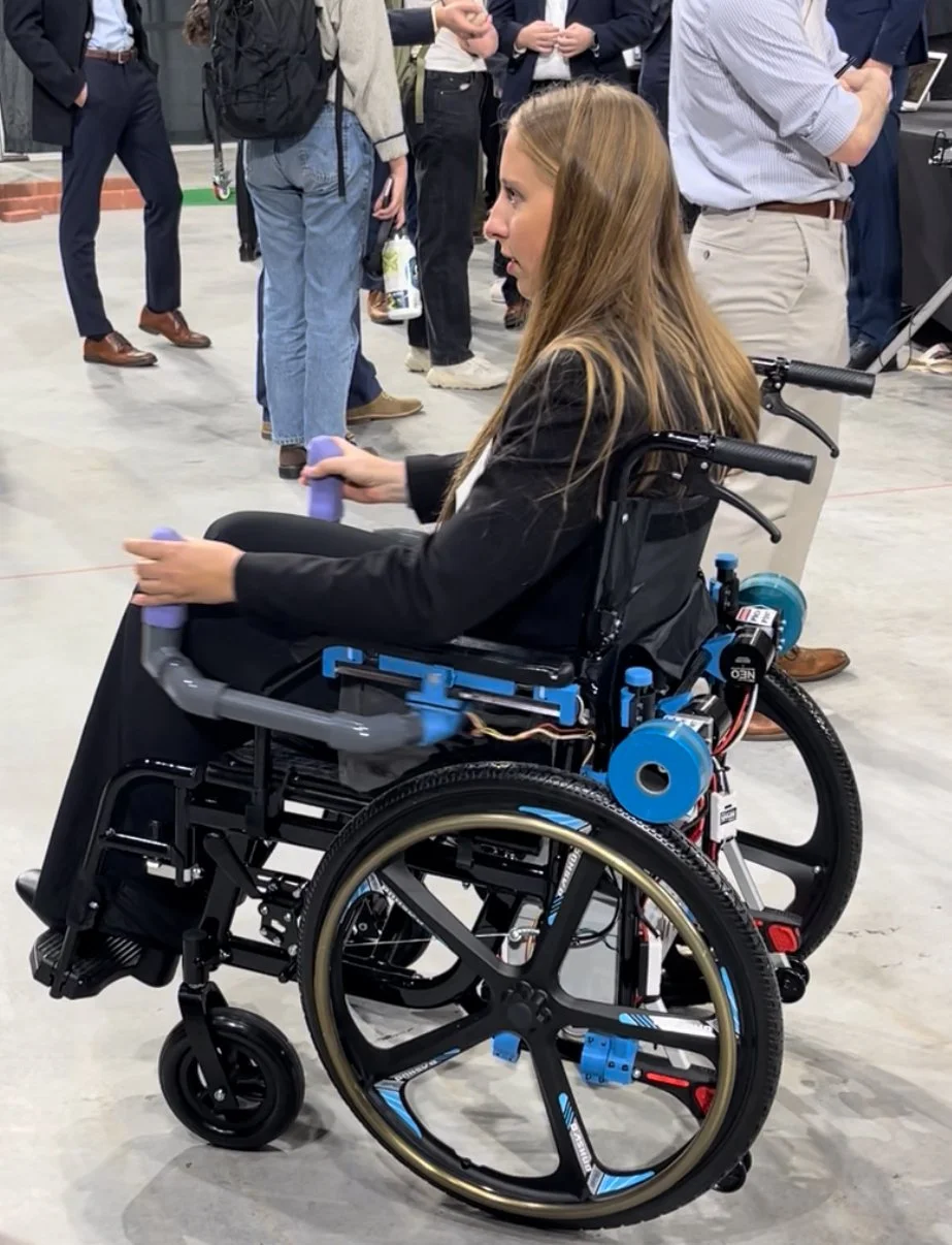 Manual wheelchair with bolt-on friction-drive assist module during testing.