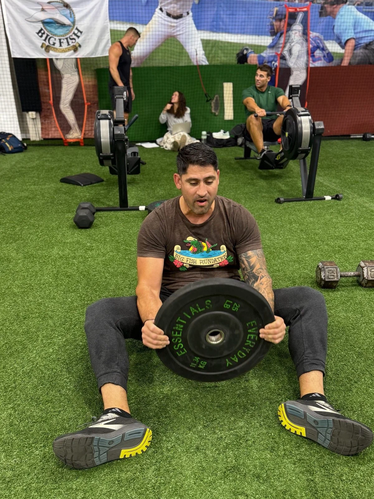 A participant holds a weight plate during a floor exercise at DT’s Row 2025.
