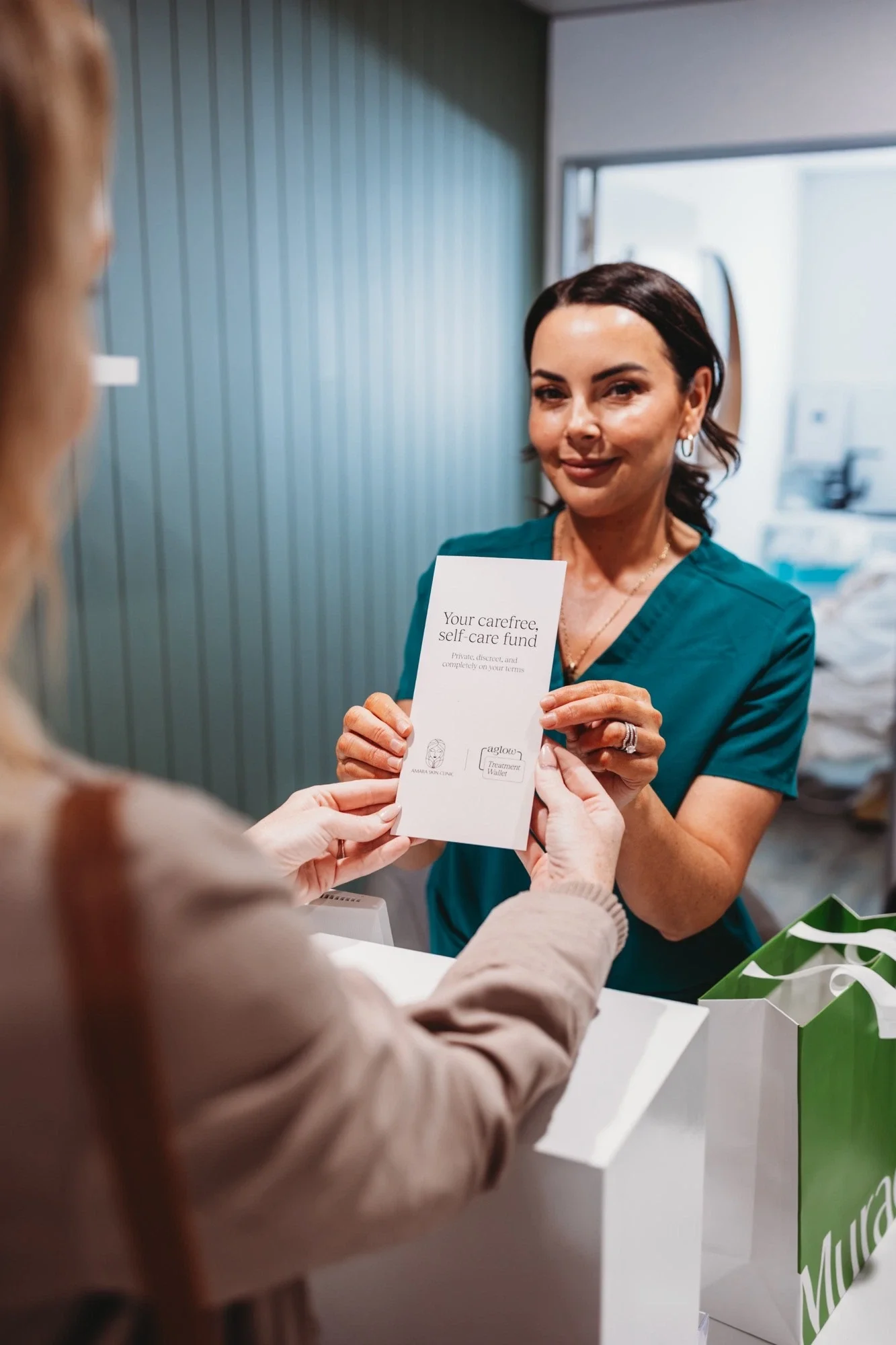 Nurse Alanna giving a client information about the AGLOW Treatment Wallet