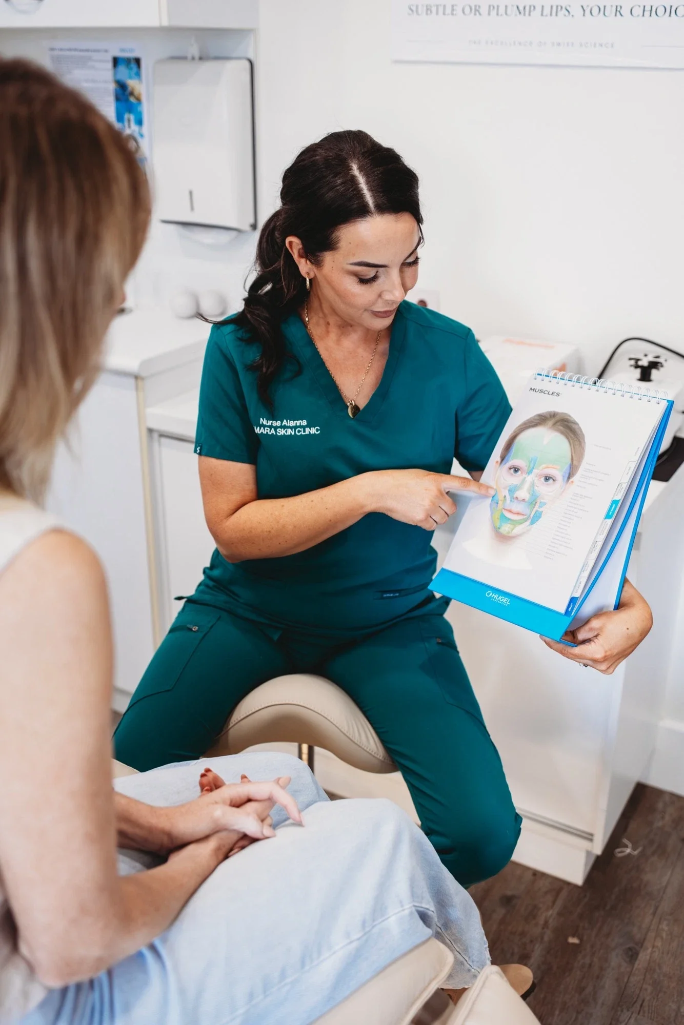 Nurse Alanna from Amara Skin Clinic showing a client a facial anatomy chart during a skin consultation