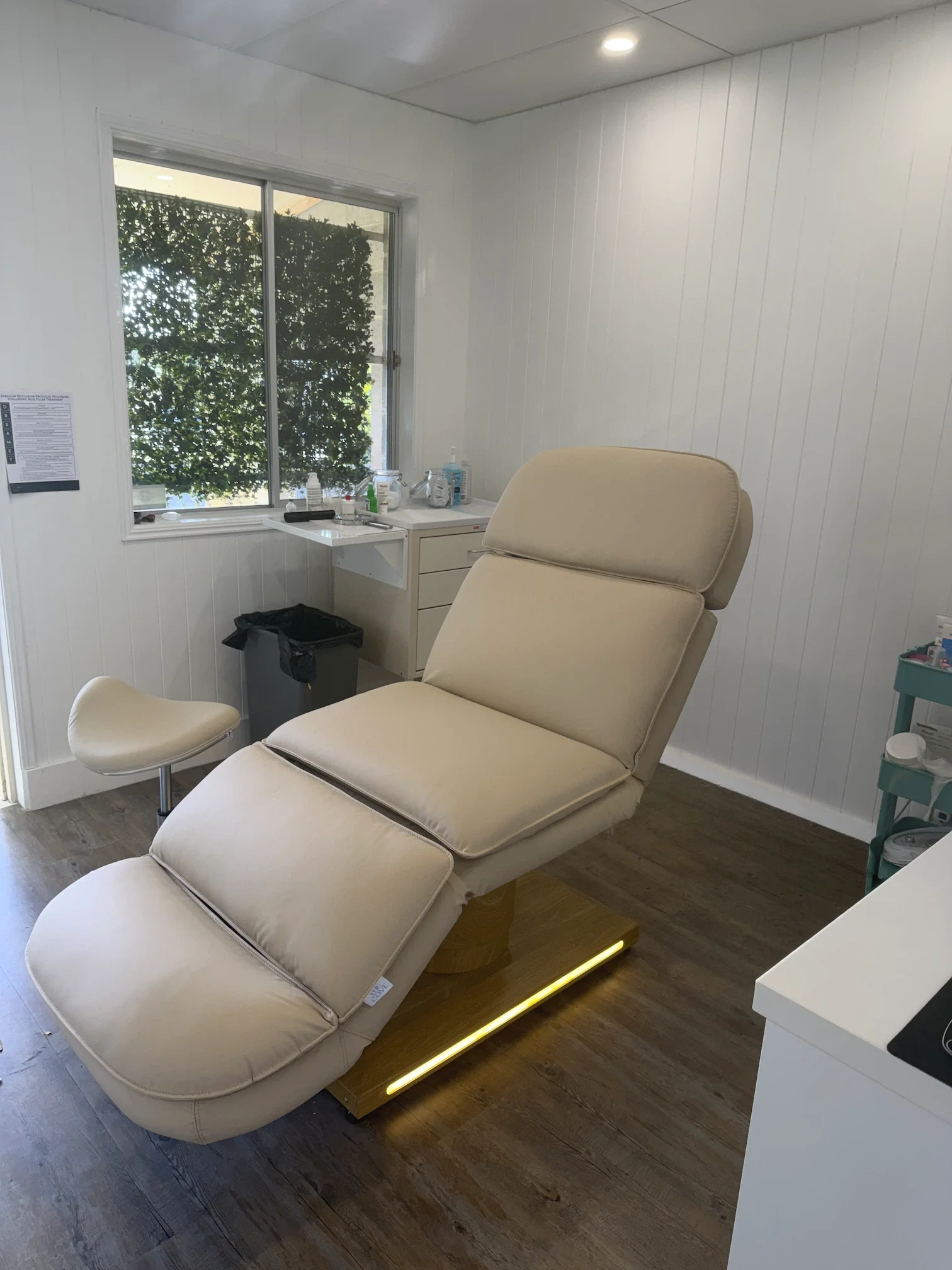 Treatment room at Amara Skin Clinic on Bribie Island, with a cream reclining treatment bed beside a window.