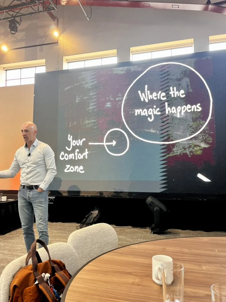 Photo of Dr Paul Taylor presenting with a slide behind him of Your comfort zone in a small circle, and Where the magic happens in a larger separate circle