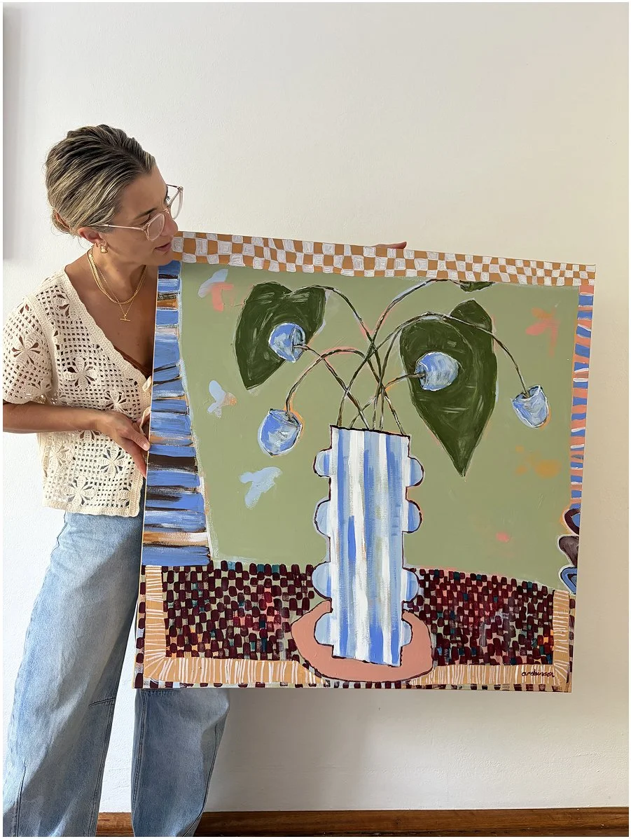 Sydney artist Anita Robinson holding the 91cm Not So Still original canvas in her studio.